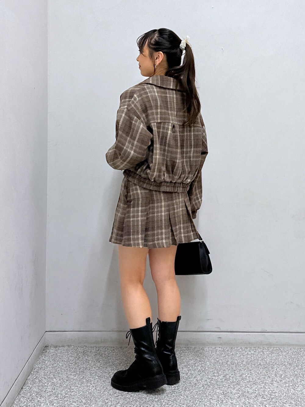 ブラウン系のスカート、ブラック系のショルダーバッグ、ブラック系のキャミソールを着用したレディースの秋コーディネートの2枚目の写真