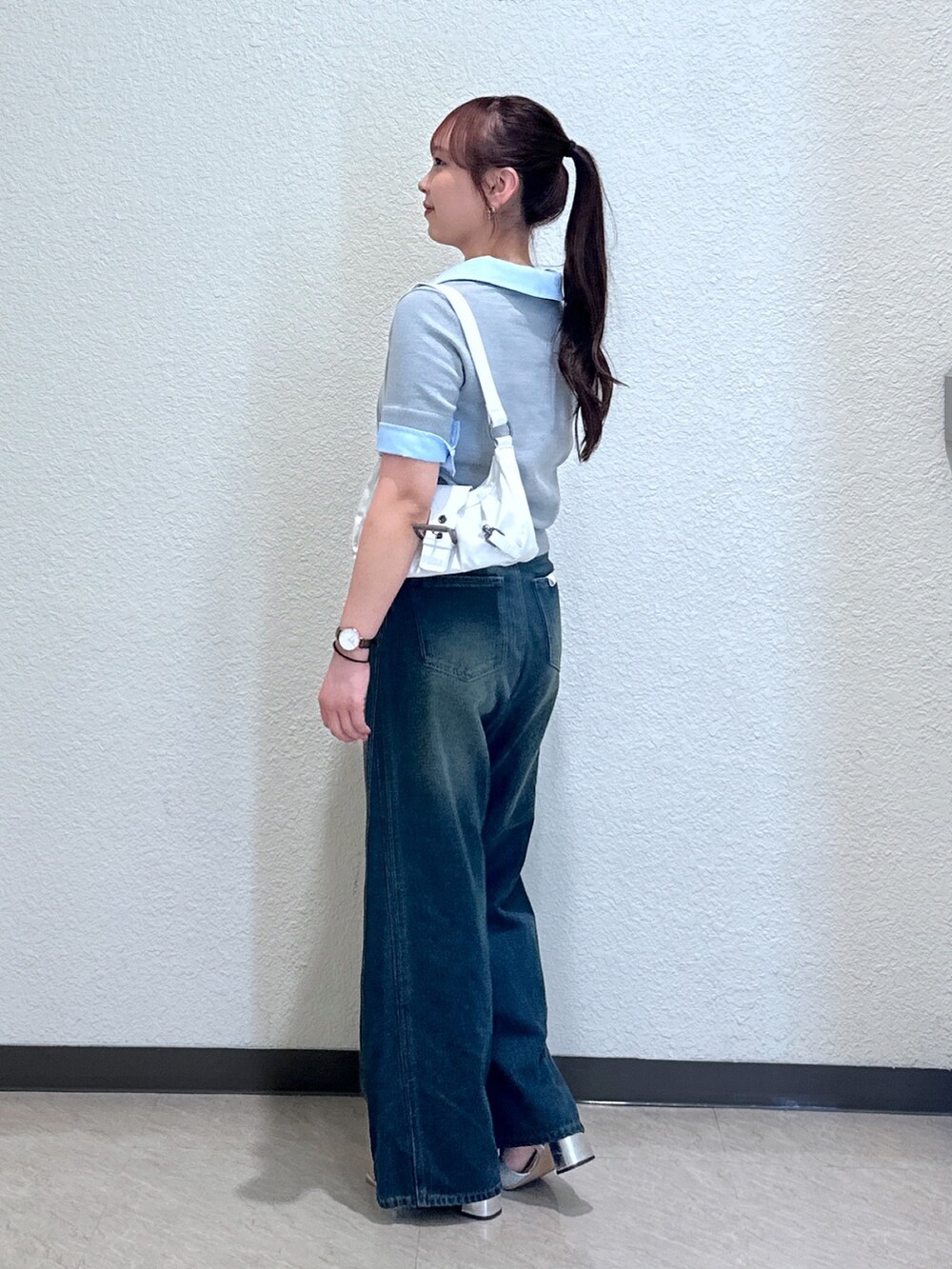 ブルー系のデニムパンツ、グレー系のニット/セーター、シルバー系のサンダルを着用したレディースの夏コーディネートの3枚目の写真