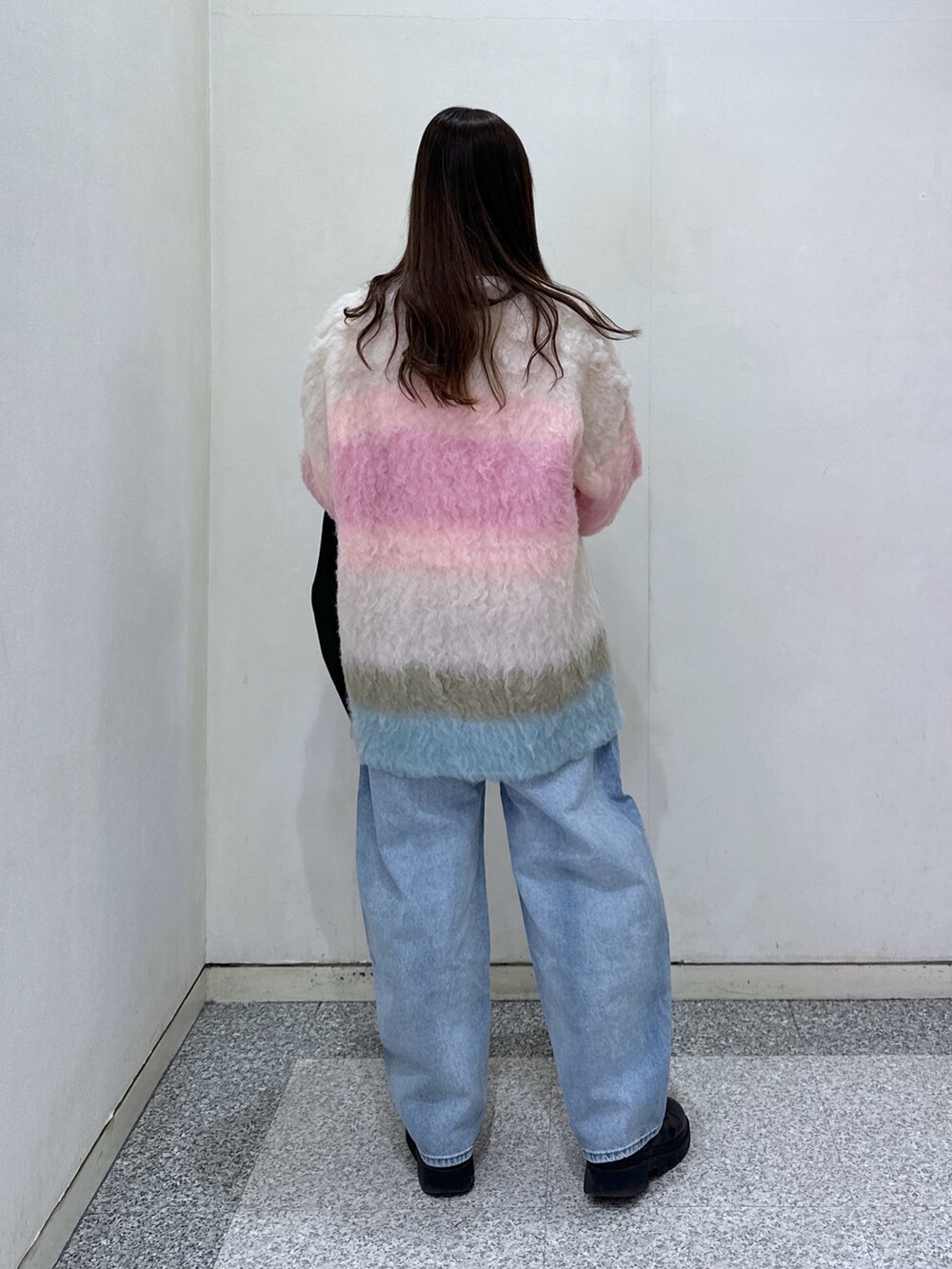 ピンク系のカーディガン/ボレロ、ホワイト系のTシャツ/カットソー、ブルー系のデニムパンツを着用したレディースの冬コーディネートの4枚目の写真