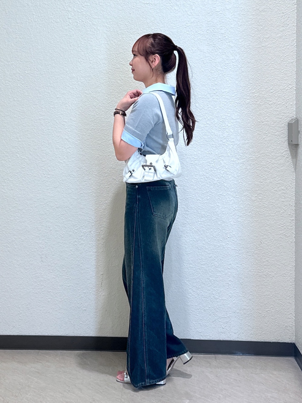 ブルー系のデニムパンツ、グレー系のニット/セーター、シルバー系のサンダルを着用したレディースの夏コーディネートの4枚目の写真