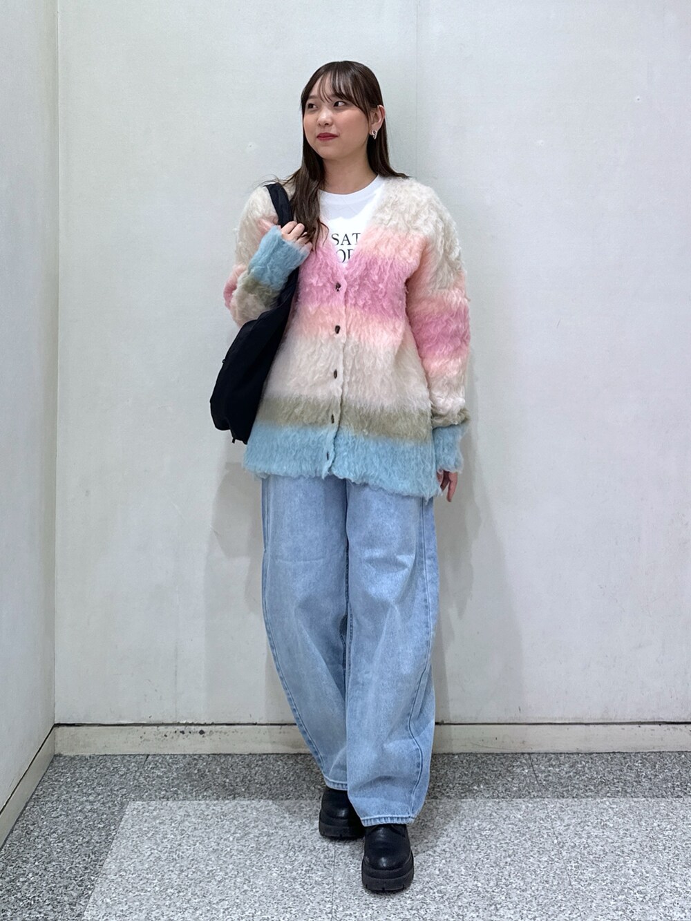 ピンク系のカーディガン/ボレロ、ホワイト系のTシャツ/カットソー、ブルー系のデニムパンツを着用したレディースの冬コーディネートの2枚目の写真