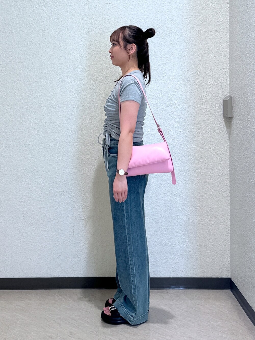 ブルー系のデニムパンツ、ブラック系のサンダル、ピンク系のショルダーバッグを着用したレディースの夏コーディネートの2枚目の写真