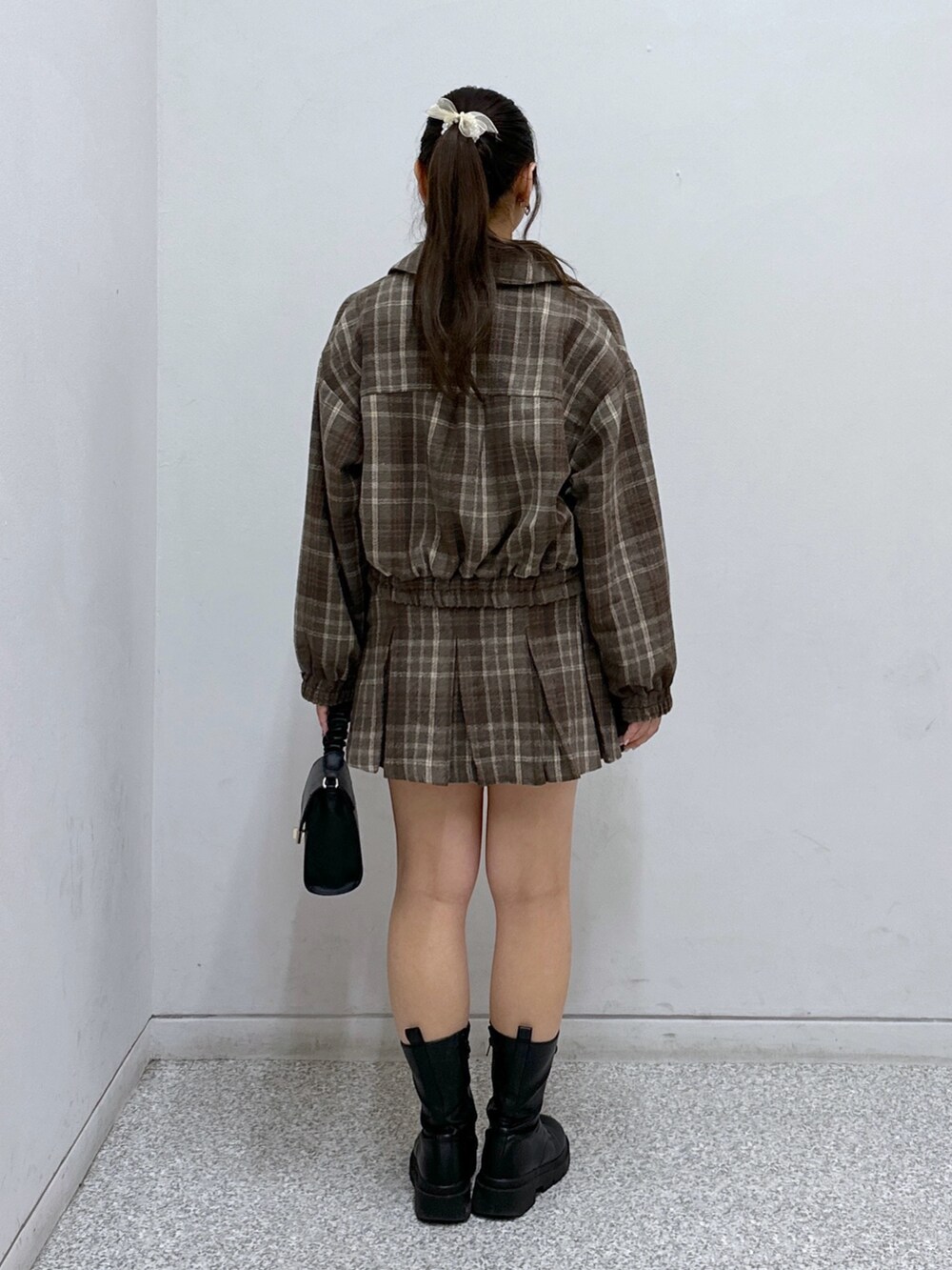 ブラウン系のスカート、ブラック系のショルダーバッグ、ブラック系のキャミソールを着用したレディースの秋コーディネートの3枚目の写真