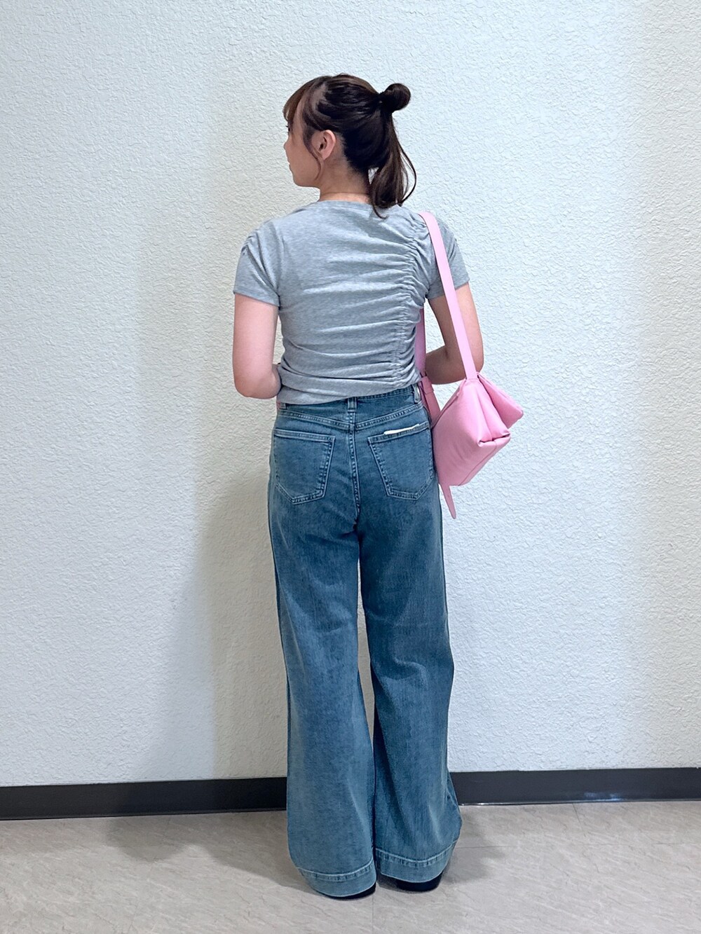 ブルー系のデニムパンツ、ブラック系のサンダル、ピンク系のショルダーバッグを着用したレディースの夏コーディネートの3枚目の写真