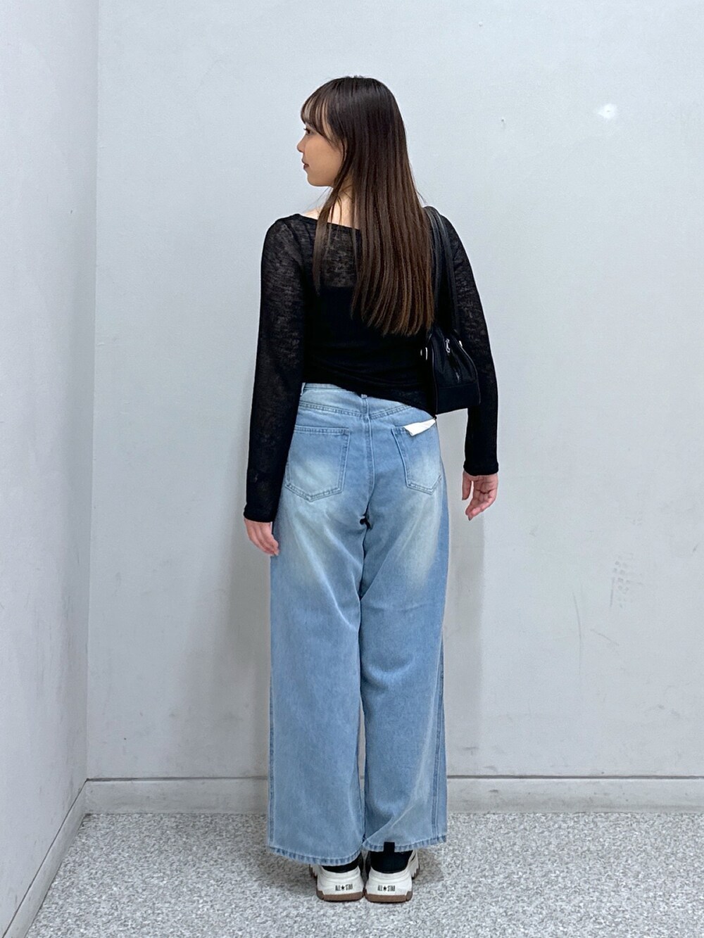 ブルー系のデニムパンツ、ブラック系のキャミソール、ブラック系のTシャツ/カットソーを着用したレディースの春コーディネートの2枚目の写真