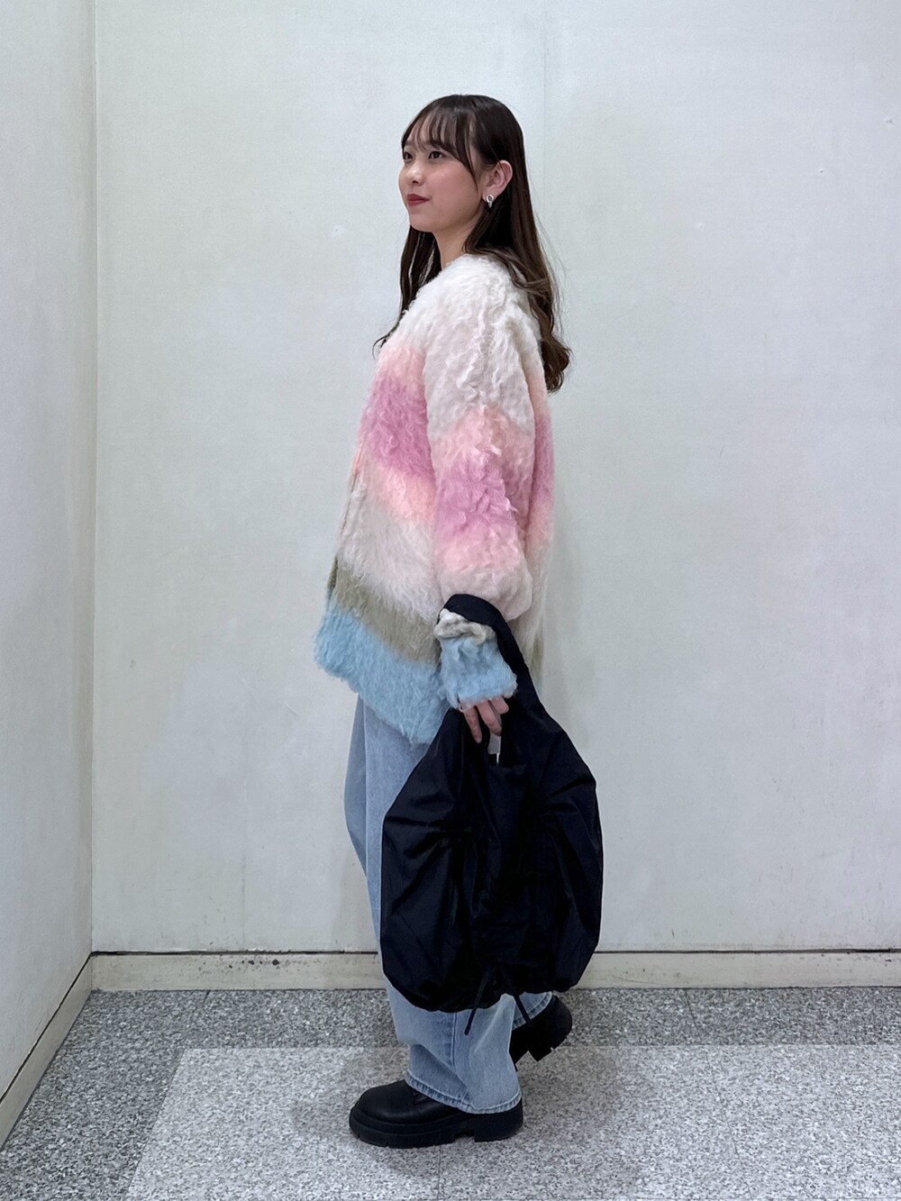 ピンク系のカーディガン/ボレロ、ホワイト系のTシャツ/カットソー、ブルー系のデニムパンツを着用したレディースの冬コーディネートの3枚目の写真