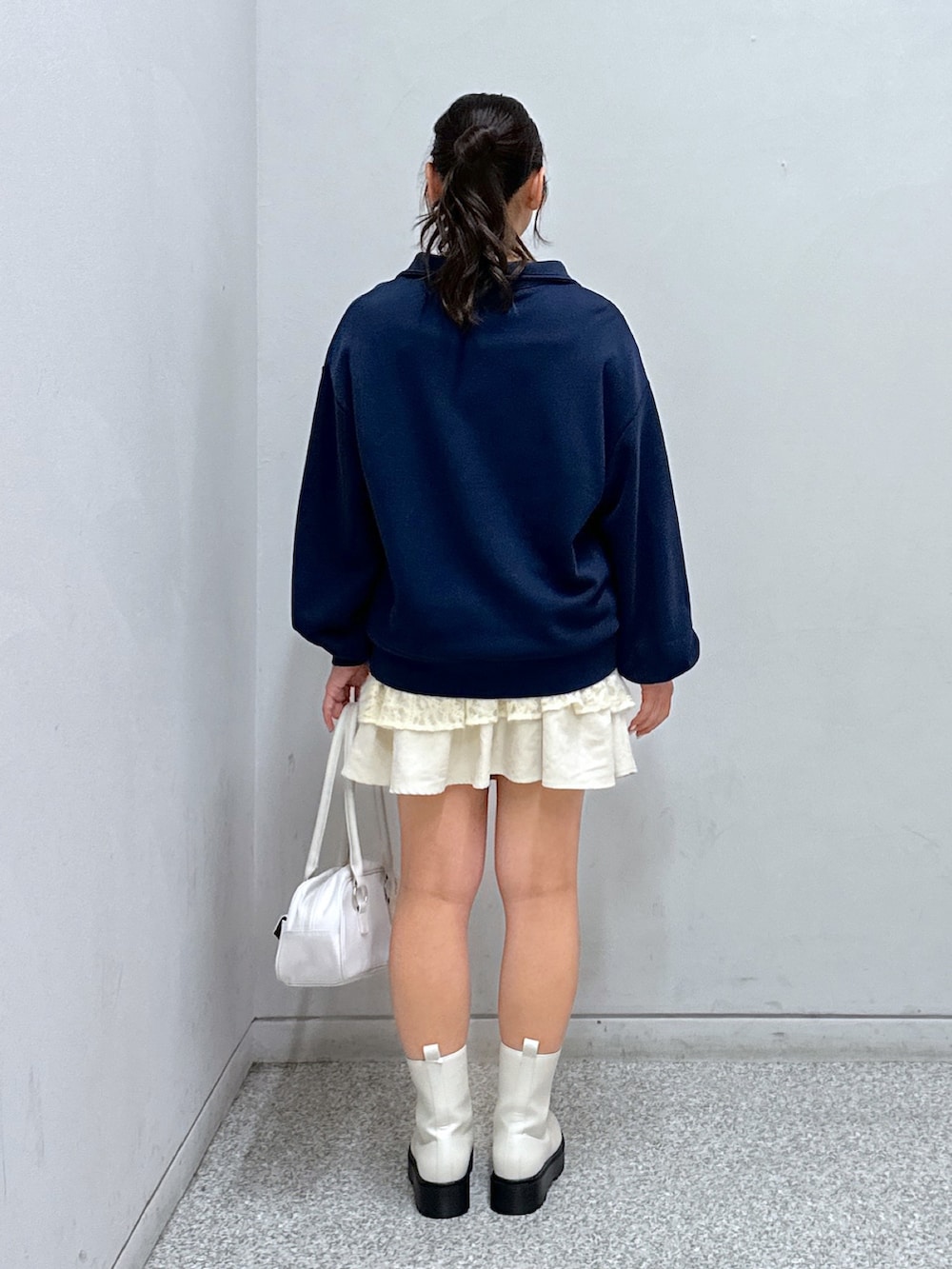ブルー系のスウェット、ホワイト系のスカート、ホワイト系のトートバッグを着用したレディースの秋コーディネートの3枚目の写真