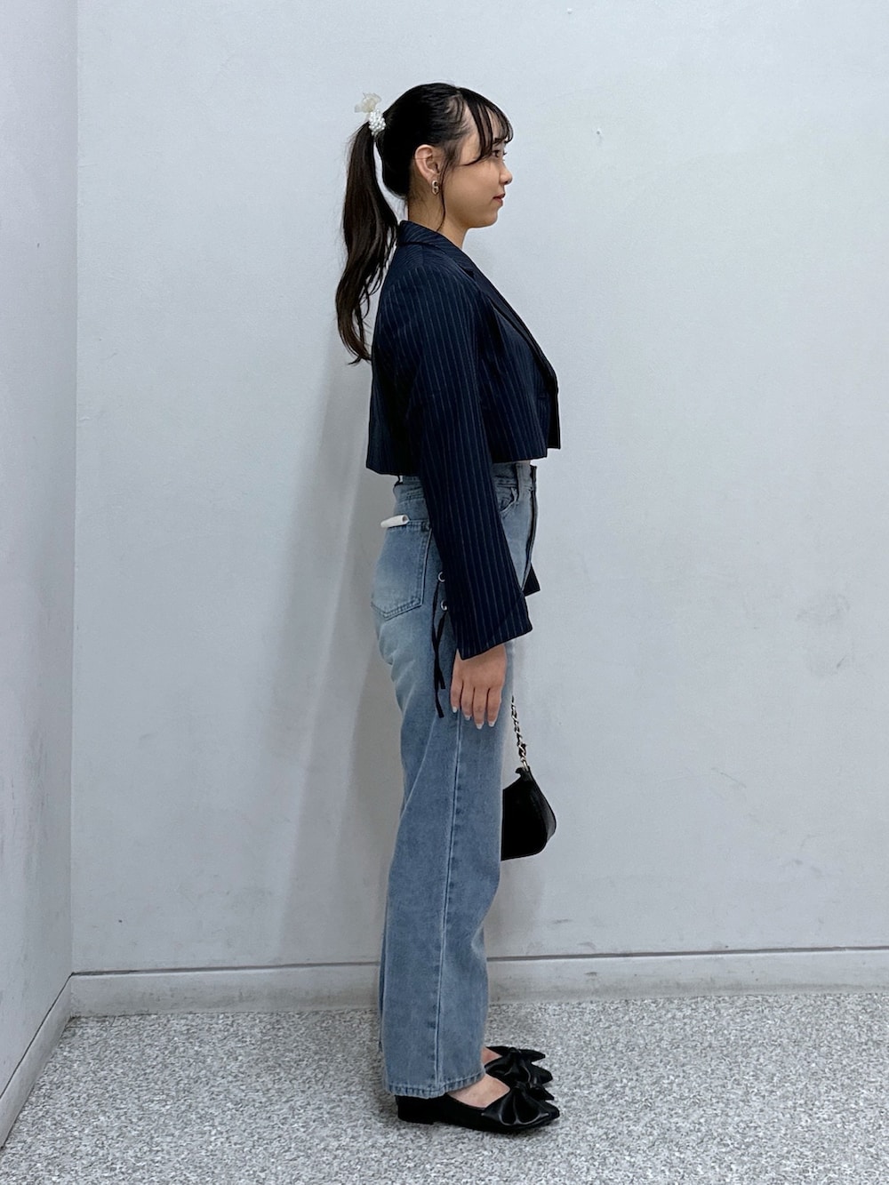 ブルー系のデニムパンツ、ブラック系のトートバッグ、ブルー系のテーラードジャケットを着用したレディースの秋コーディネートの2枚目の写真