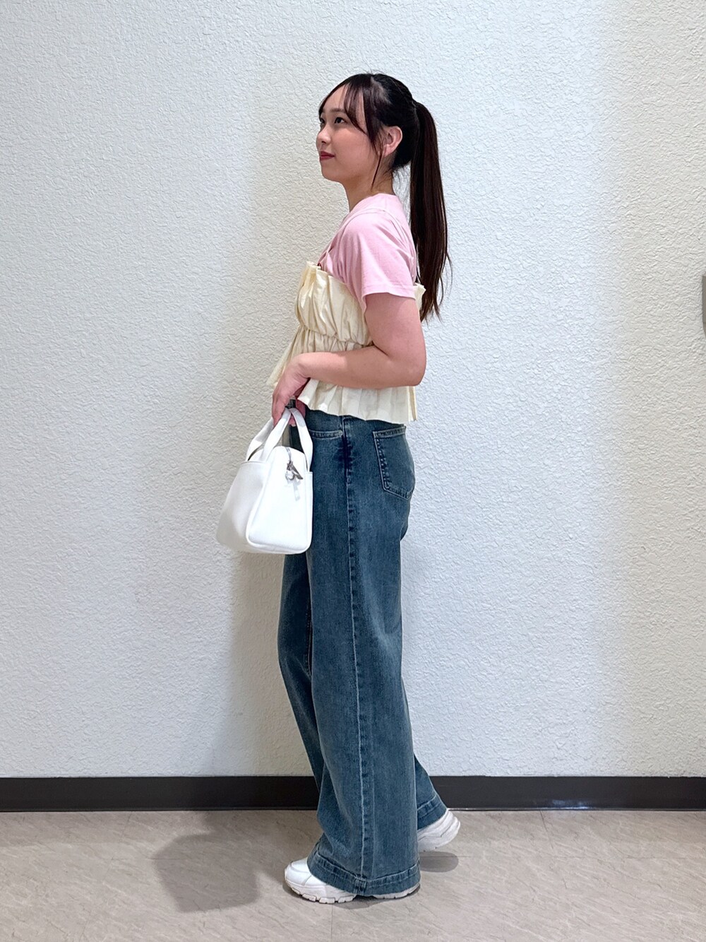 ピンク系のTシャツ/カットソー、ホワイト系のシャツ/ブラウス、ブルー系のデニムパンツを着用したレディースの春コーディネートの3枚目の写真