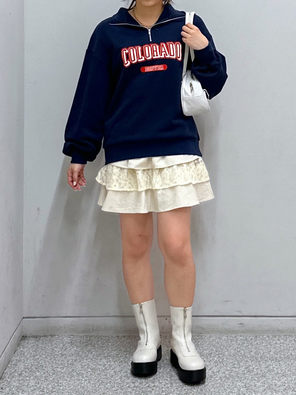 ブルー系のスウェット、ホワイト系のスカート、ホワイト系のトートバッグを着用したレディースの秋コーディネートの4枚目の写真