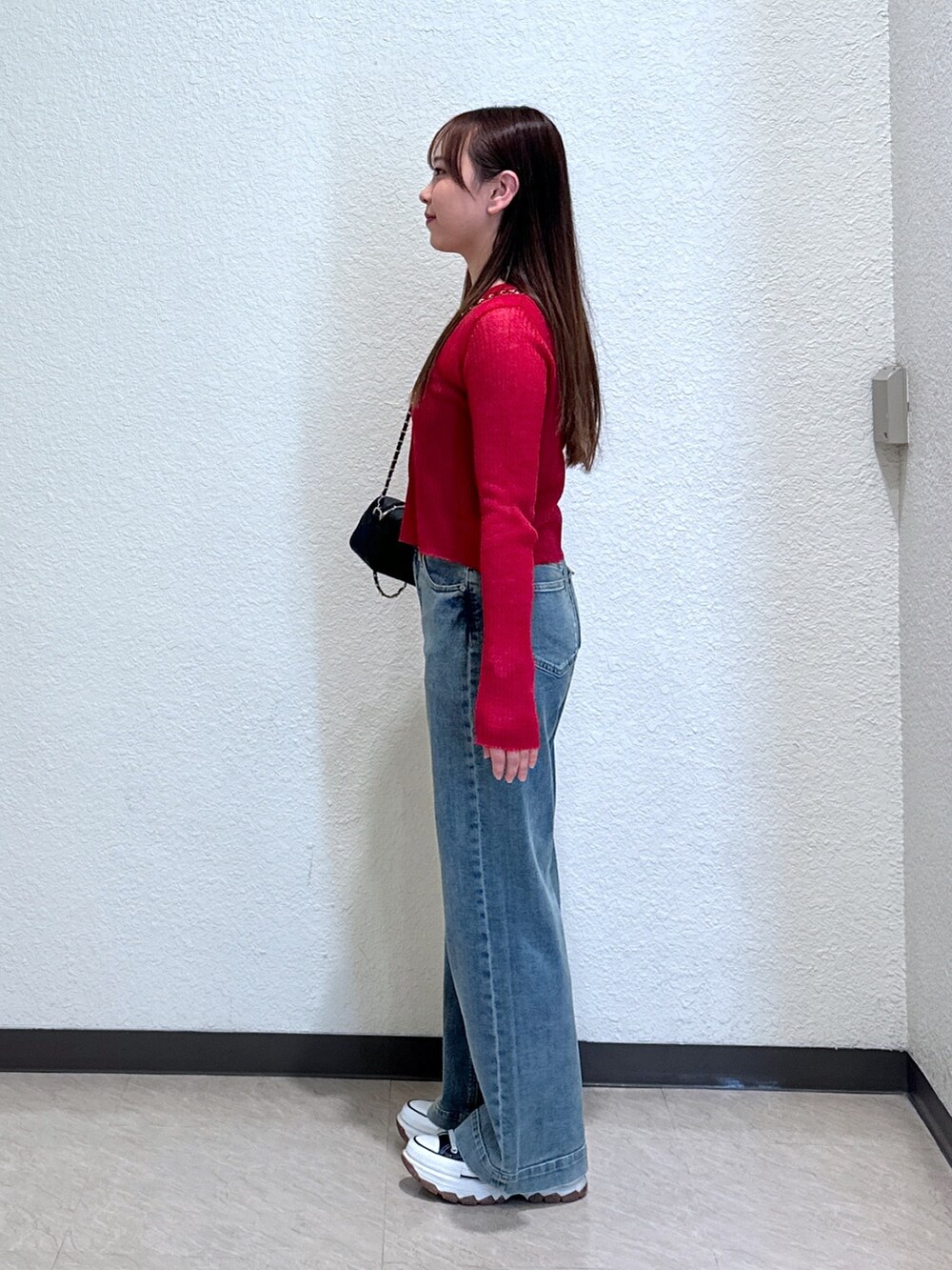 ブルー系のデニムパンツ、ブラック系のショルダーバッグ、ブラック系のキャミソールを着用したレディースの夏コーディネートの3枚目の写真