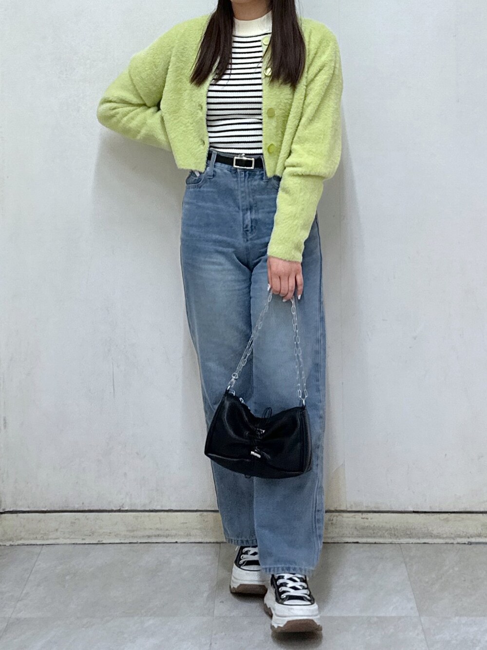 ホワイト系のニット/セーター、グリーン系のカーディガン/ボレロ、ブラック系のハンドバッグを着用したレディースの冬コーディネートの4枚目の写真