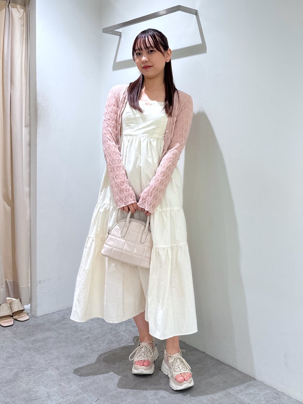 ホワイト系のワンピース、ピンク系のカーディガン/ボレロ、ホワイト系のショルダーバッグを着用したレディースの春コーディネートの2枚目の写真