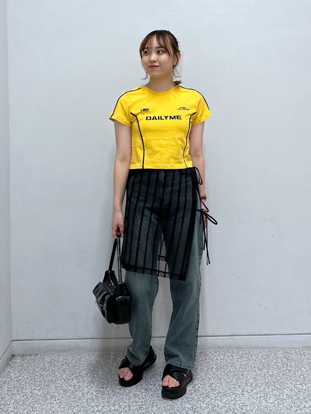 ブラック系のスカート、ブルー系のデニムパンツ、オレンジ系のTシャツ/カットソーを着用したレディースの秋コーディネートの2枚目の写真