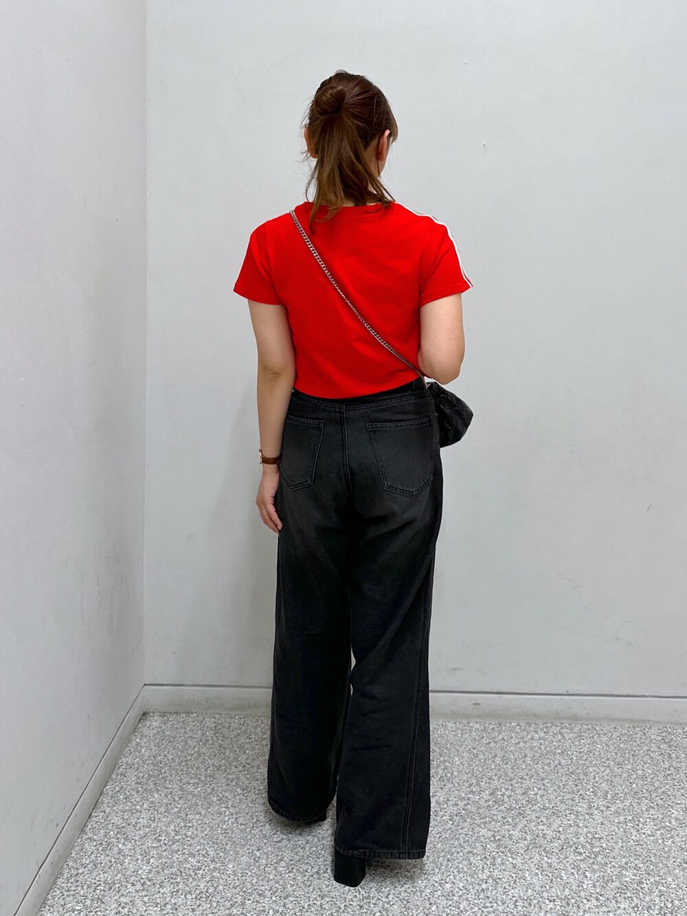 ブラック系のデニムパンツ、レッド系のTシャツ/カットソー、ブラック系のサンダルを着用したレディースの夏コーディネートの2枚目の写真