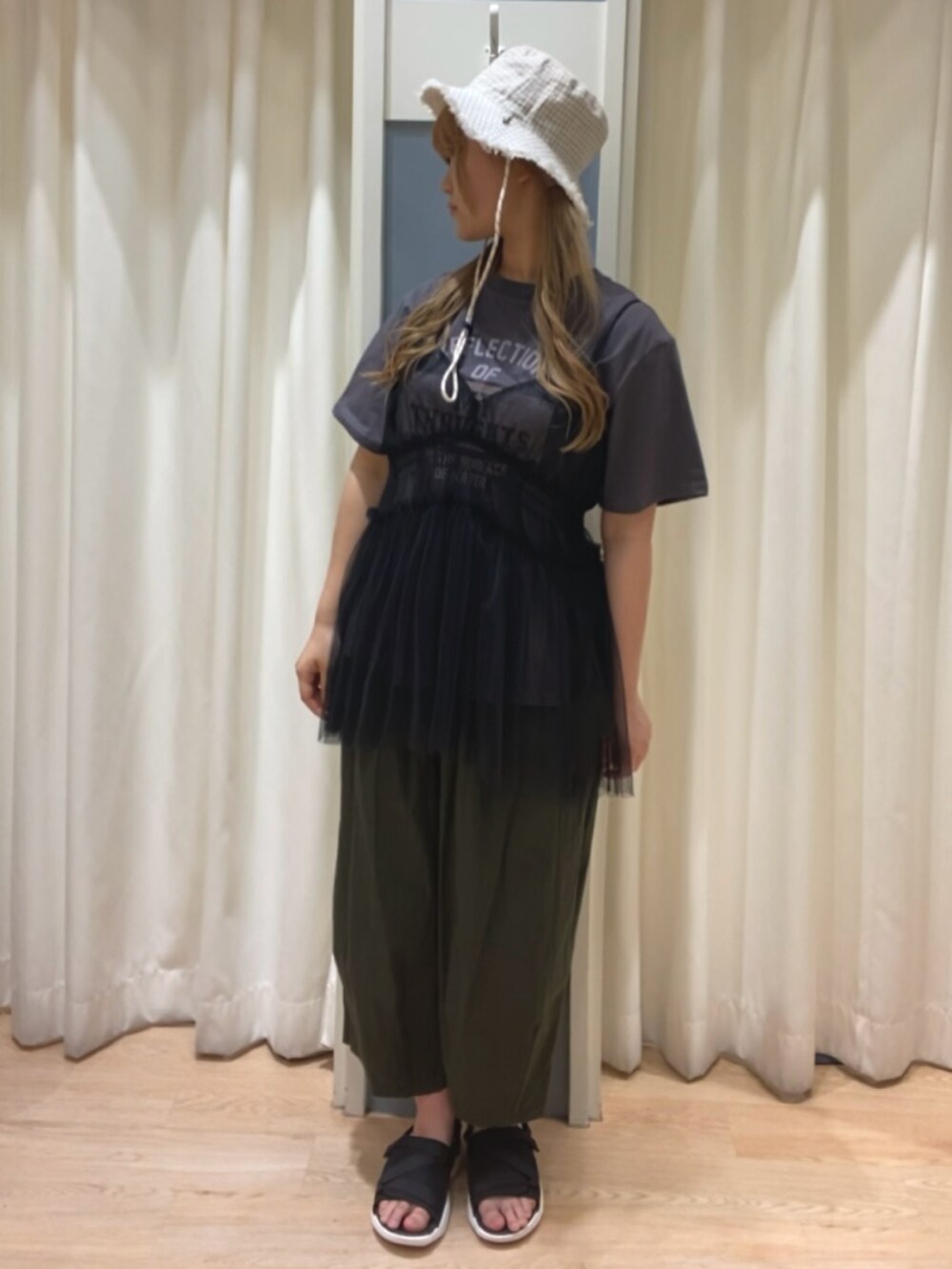 グレー系のTシャツ/カットソー、グリーン系のその他パンツ、ブラック系のサンダルを着用したレディースの春コーディネートの2枚目の写真