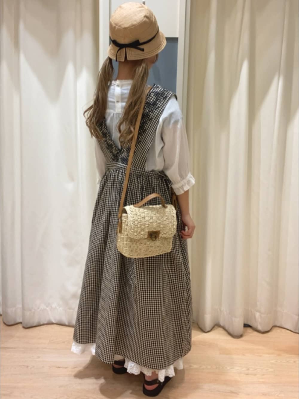 グレー系のワンピース、ブラック系のサンダル、ホワイト系のスカートを着用したレディースの春コーディネートの2枚目の写真