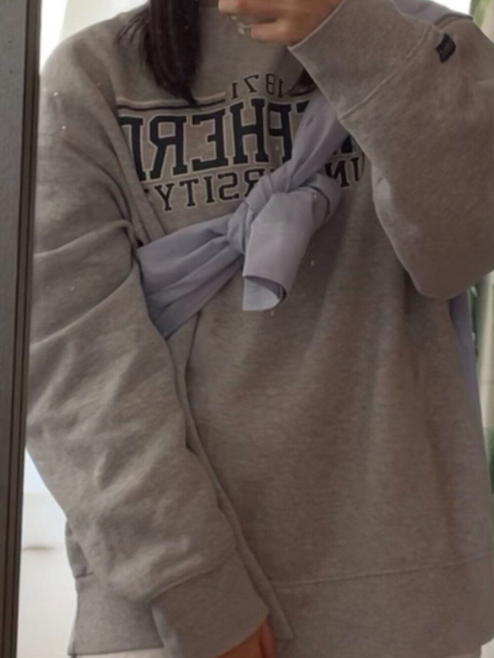 グレー系のスウェット、ベージュ系のスニーカー、ブラック系のその他パンツを着用したレディースの春コーディネートの2枚目の写真