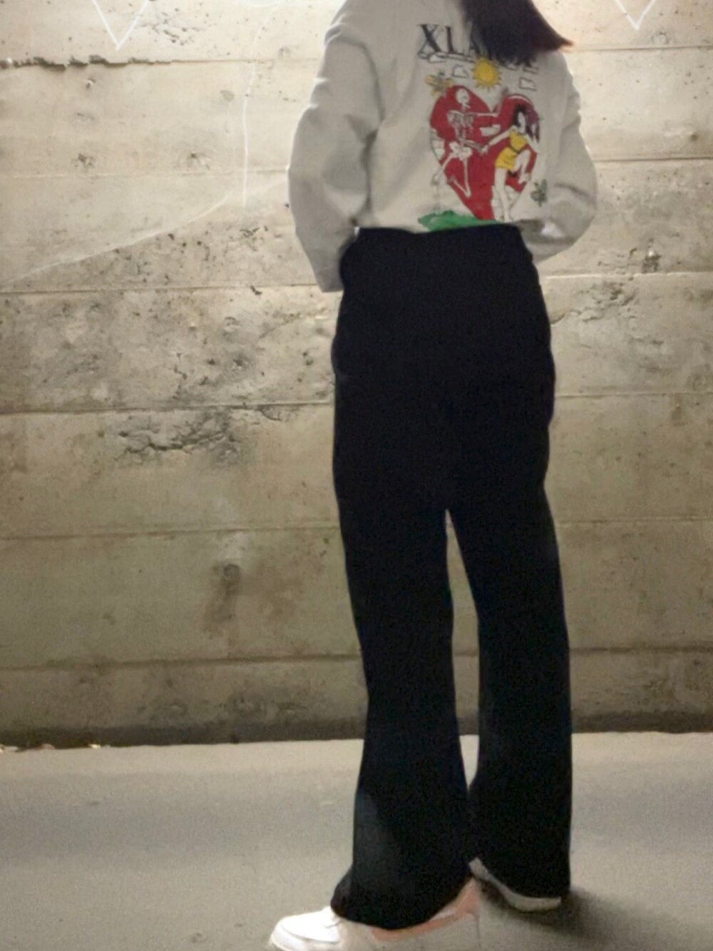 ブラック系のスラックス、ホワイト系のTシャツ/カットソー、ホワイト系のスニーカーを着用したレディースの秋コーディネートの2枚目の写真