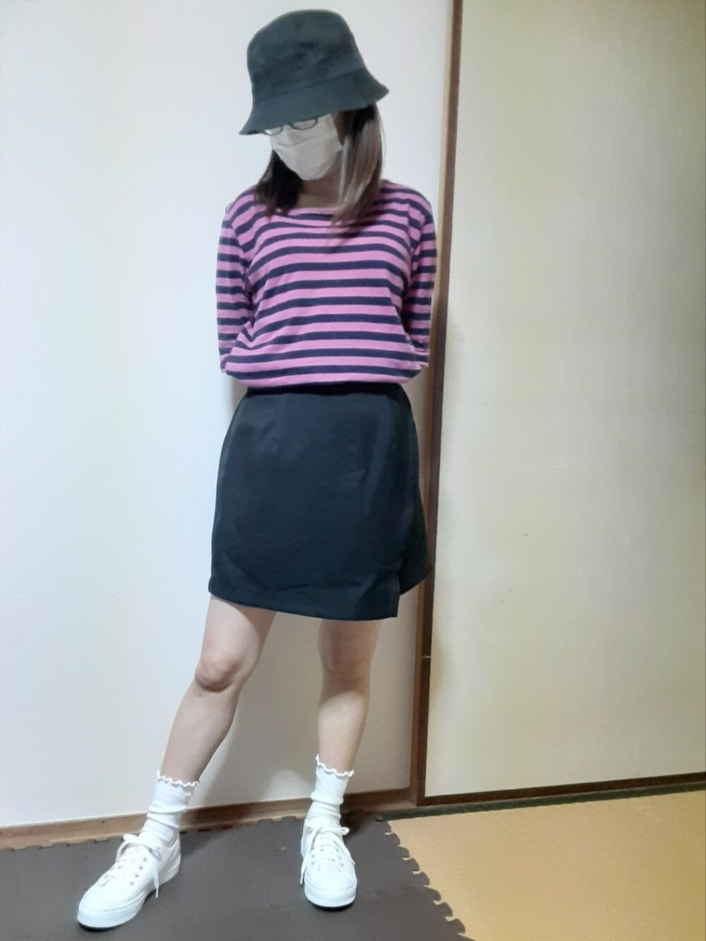 ブラック系のスカート、ホワイト系のスニーカーを着用したレディースの夏コーディネートの2枚目の写真