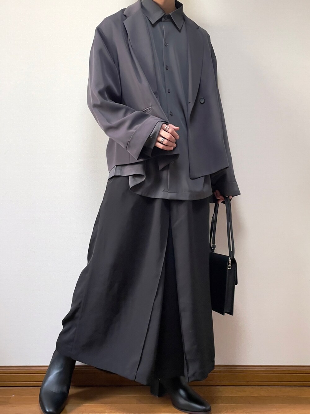 ブラック系のショルダーバッグ、ブラック系のその他パンツ、ブラック系のブーツを着用したメンズの春コーディネートの2枚目の写真