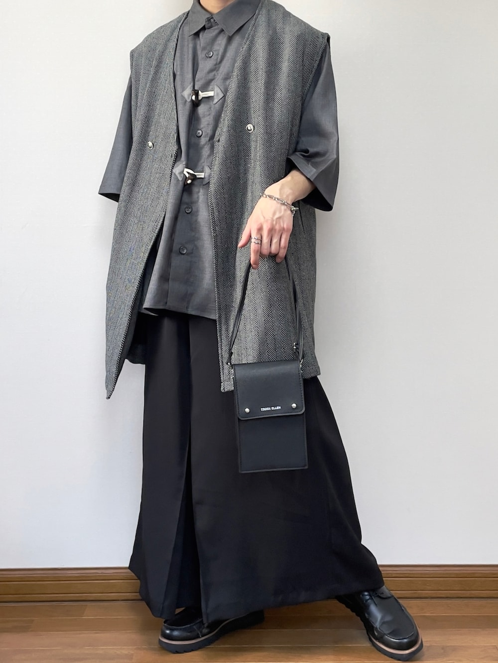 グレー系のベスト、ブラック系のその他パンツ、ブラック系のローファーを着用したメンズの春コーディネートの2枚目の写真