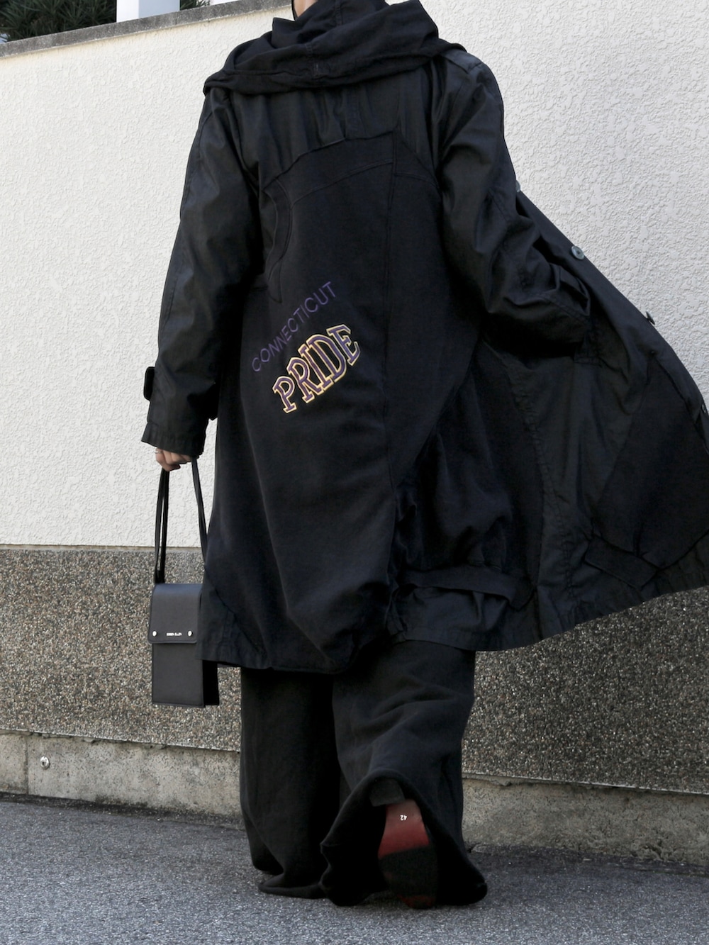 ブラック系のショルダーバッグ、ブラック系のスウェットパンツ、ブラック系のブーツを着用したメンズの秋コーディネートの3枚目の写真