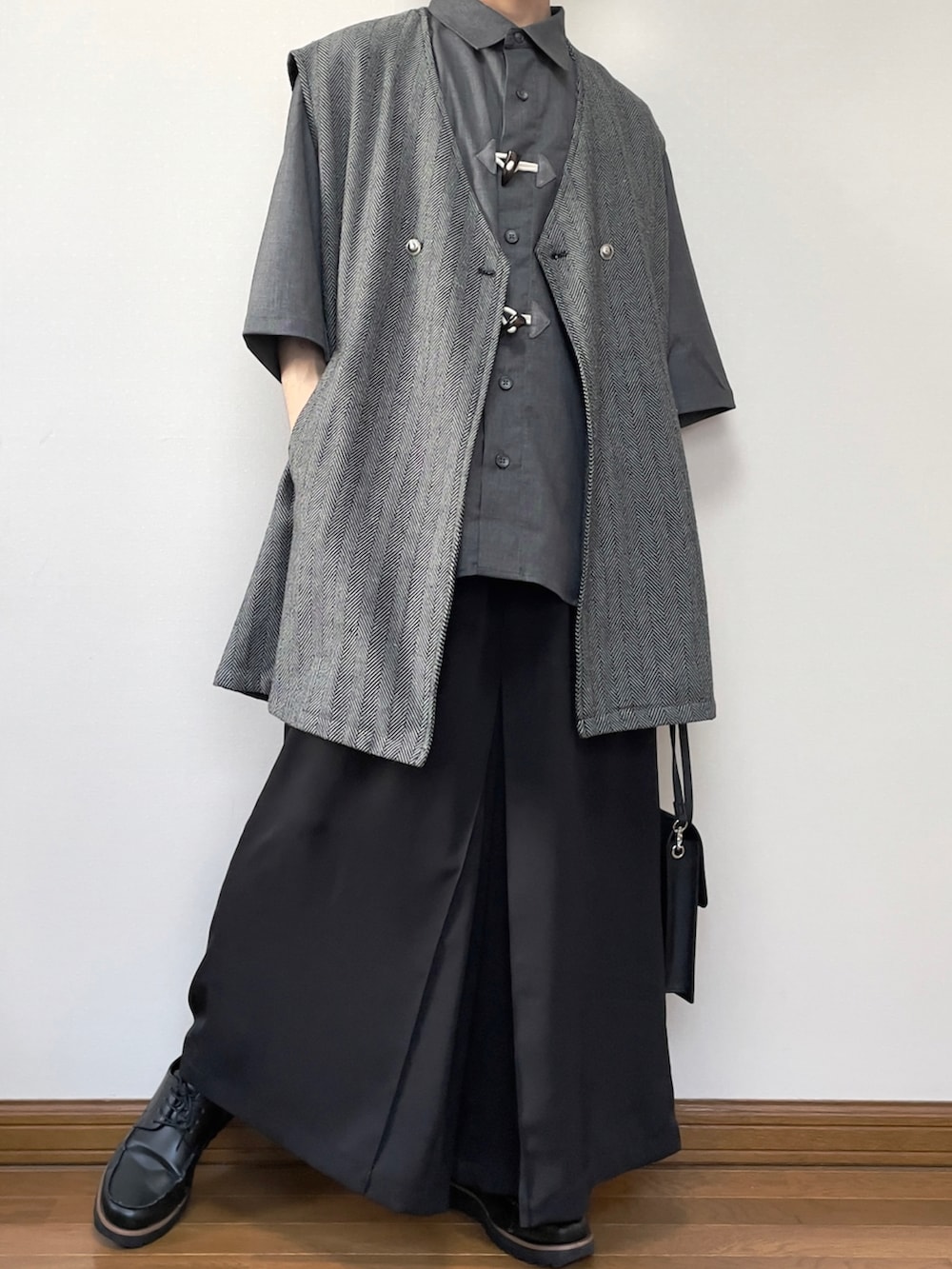 グレー系のベスト、ブラック系のその他パンツ、ブラック系のローファーを着用したメンズの春コーディネートの3枚目の写真