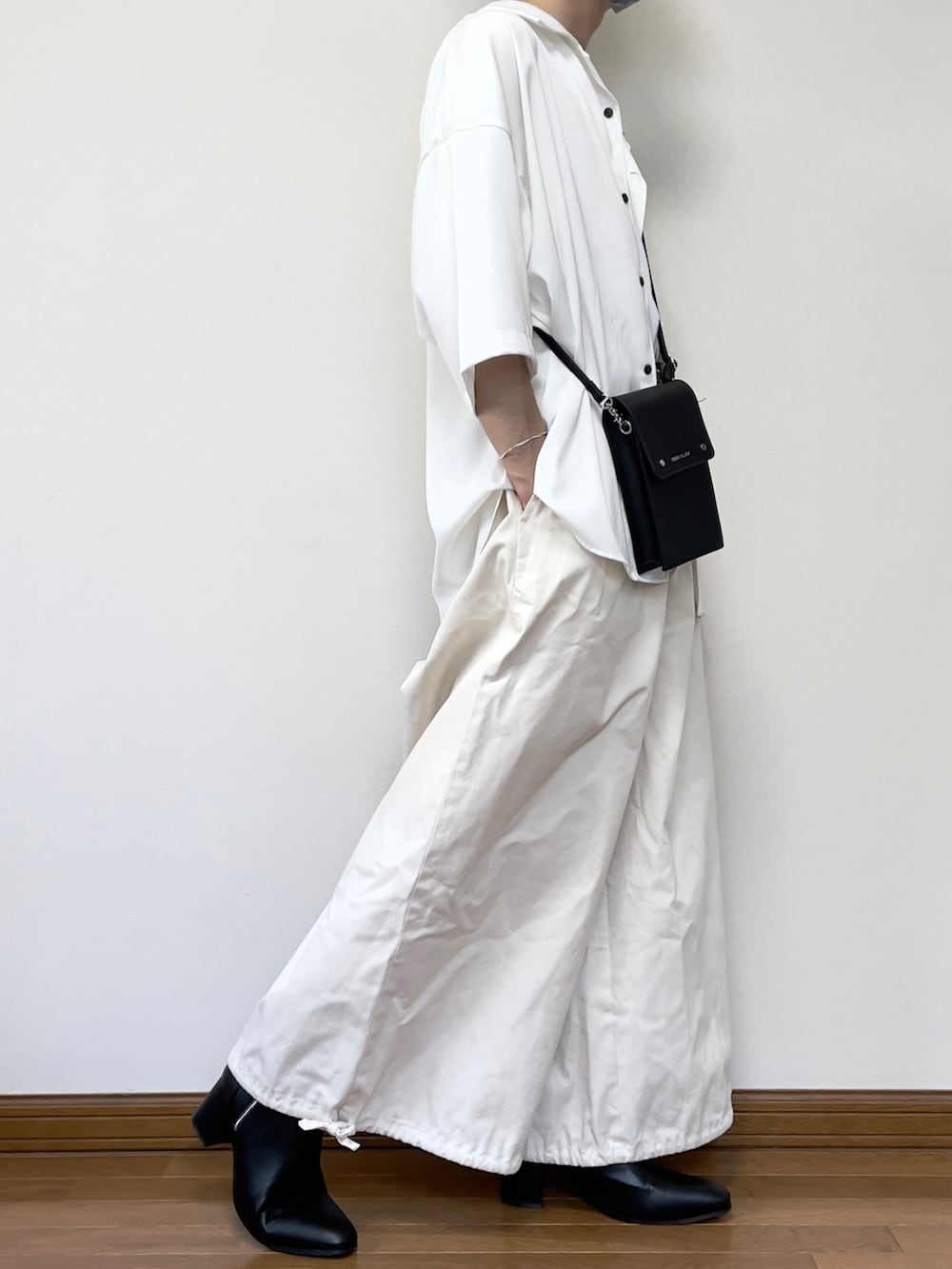 ブラック系のブーツ、ベージュ系のその他パンツ、ブラック系のショルダーバッグを着用したメンズの夏コーディネートの3枚目の写真