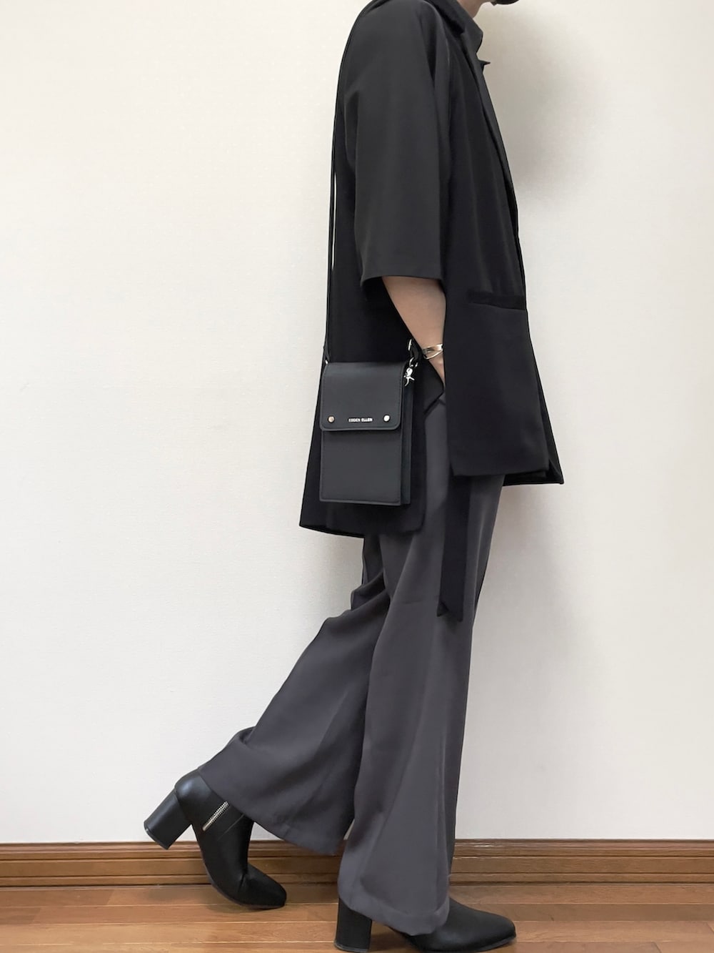 グレー系のスラックス、ブラック系のブーツ、ブラック系のベストを着用したメンズの夏コーディネートの3枚目の写真