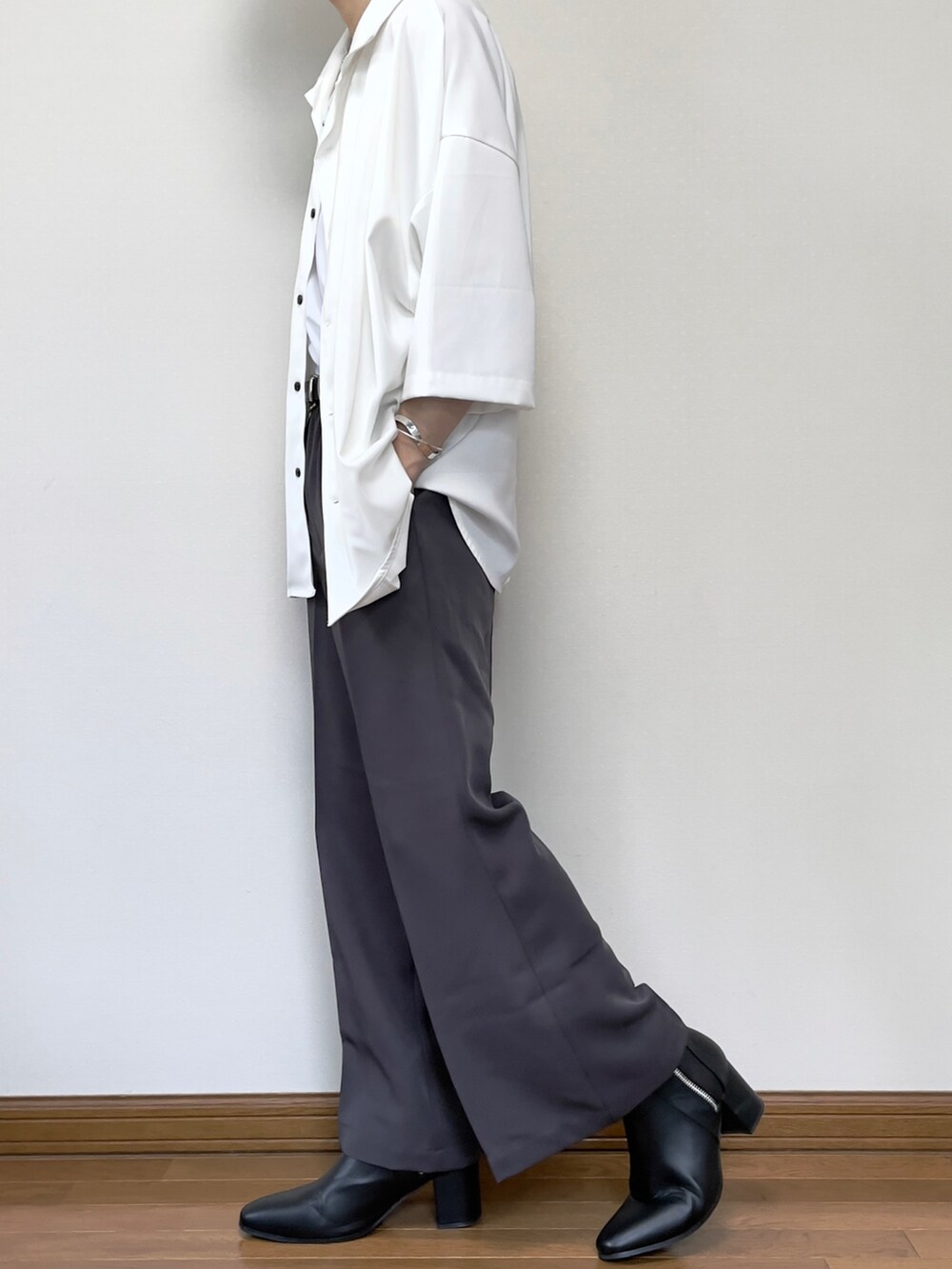 グレー系のスラックス、ブラック系のブーツ、ブラック系のショルダーバッグを着用したメンズの夏コーディネートの2枚目の写真