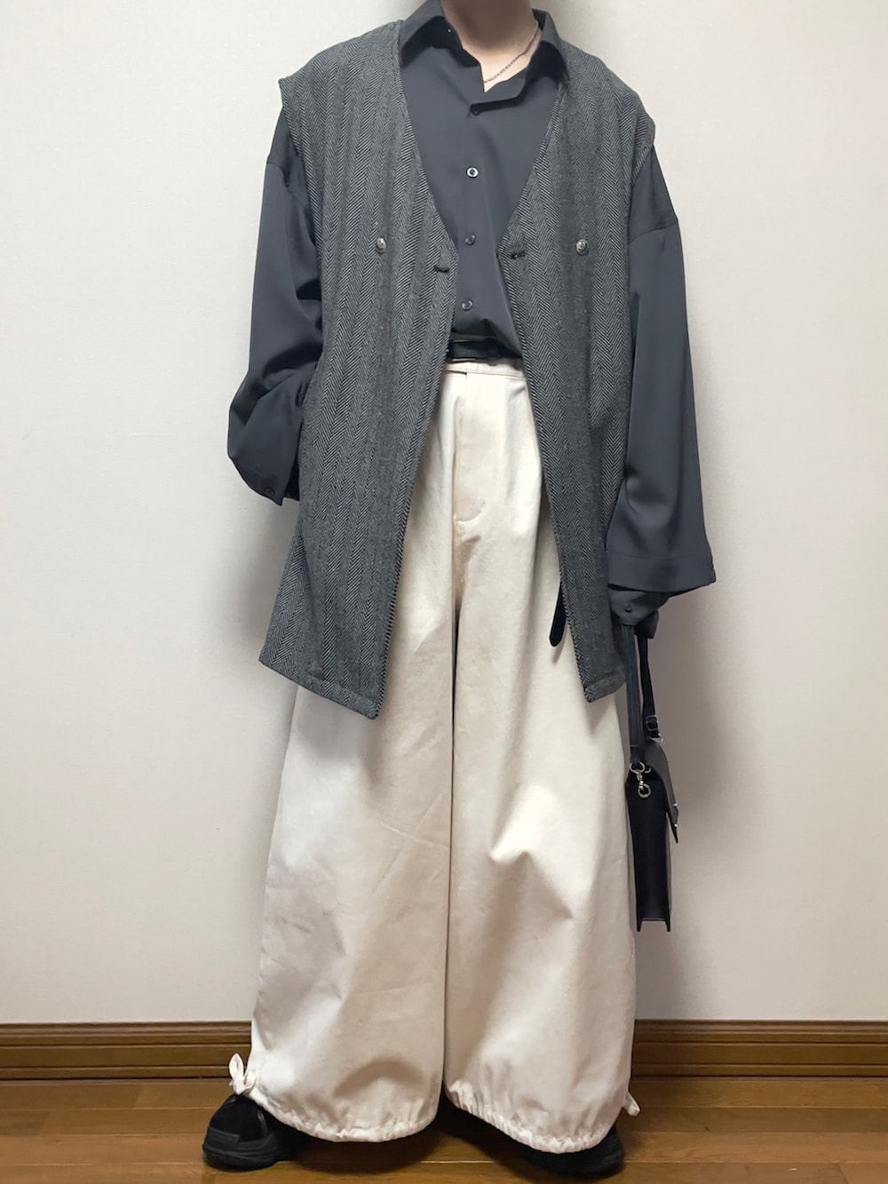 グレー系のベスト、グレー系のシャツ/ブラウス、ブラック系のショルダーバッグを着用したメンズの春コーディネートの2枚目の写真