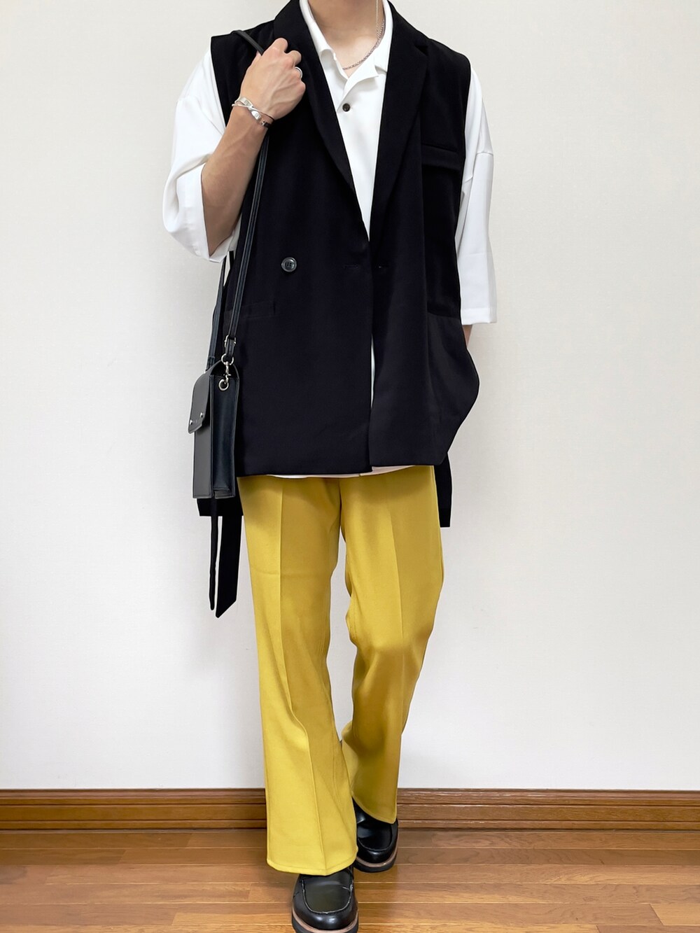 イエロー系のスラックス、ブラック系のベスト、ホワイト系のシャツ/ブラウスを着用したメンズの夏コーディネートの3枚目の写真