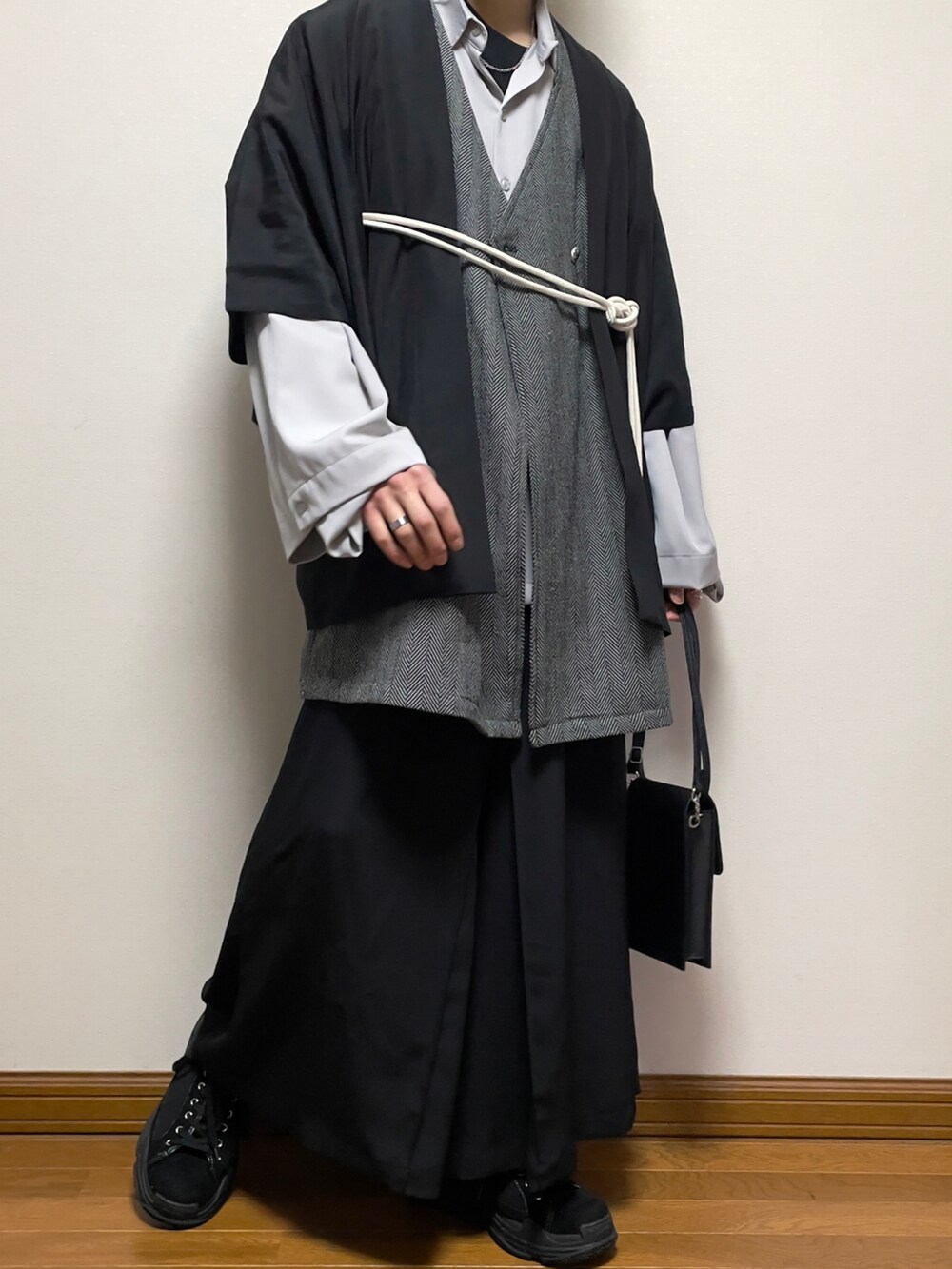 グレー系のベスト、ベージュ系のトレンチコート、グレー系のシャツ/ブラウスを着用したメンズの春コーディネートの2枚目の写真