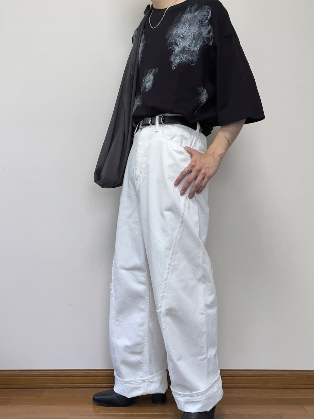 ホワイト系のデニムパンツ、ブラック系のブーツ、ブラック系のTシャツ/カットソーを着用したメンズの夏コーディネートの2枚目の写真