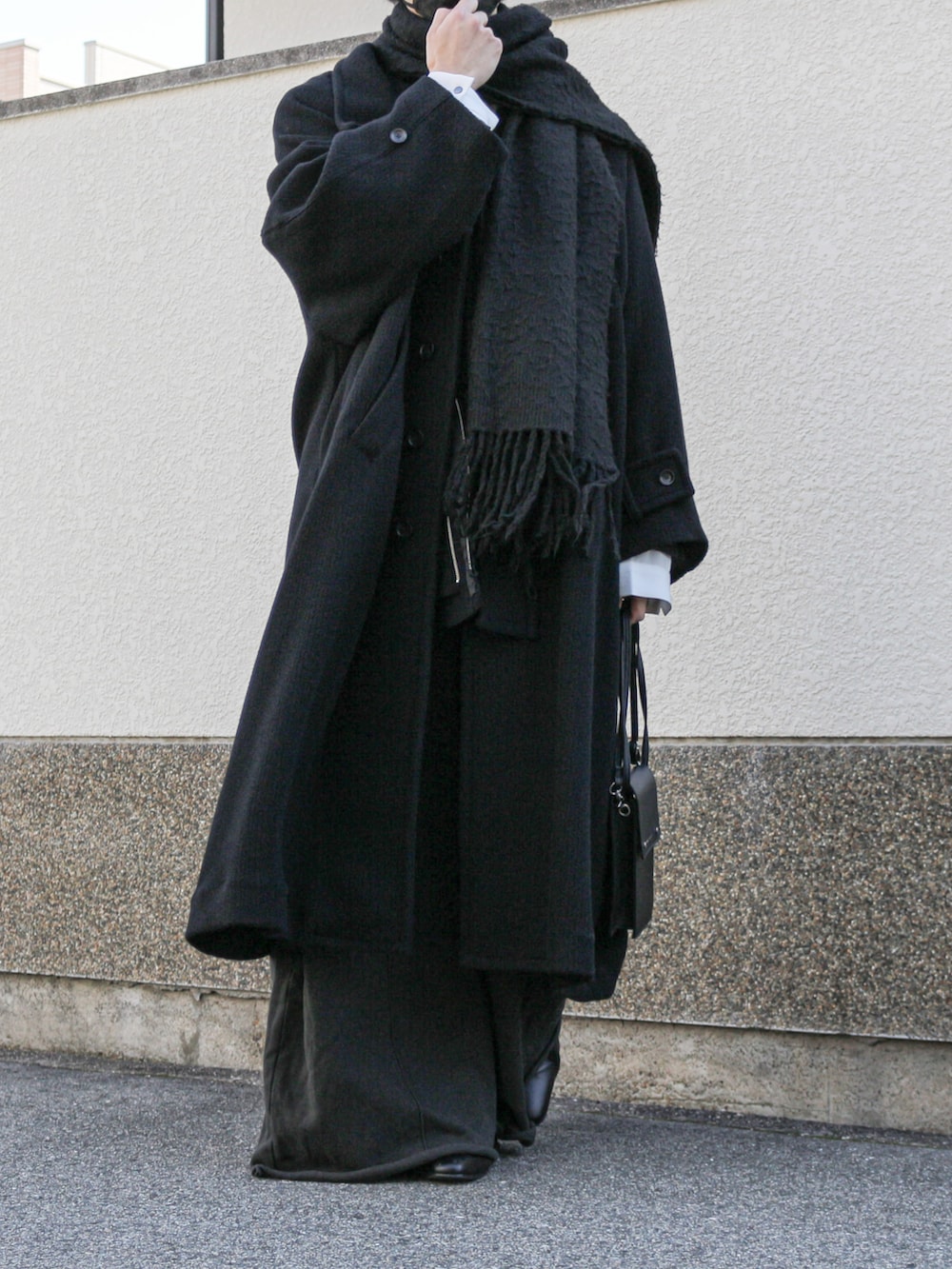 ブラック系のその他アウター、ブラック系のショルダーバッグ、ブラック系のスウェットパンツを着用したメンズの冬コーディネートの4枚目の写真