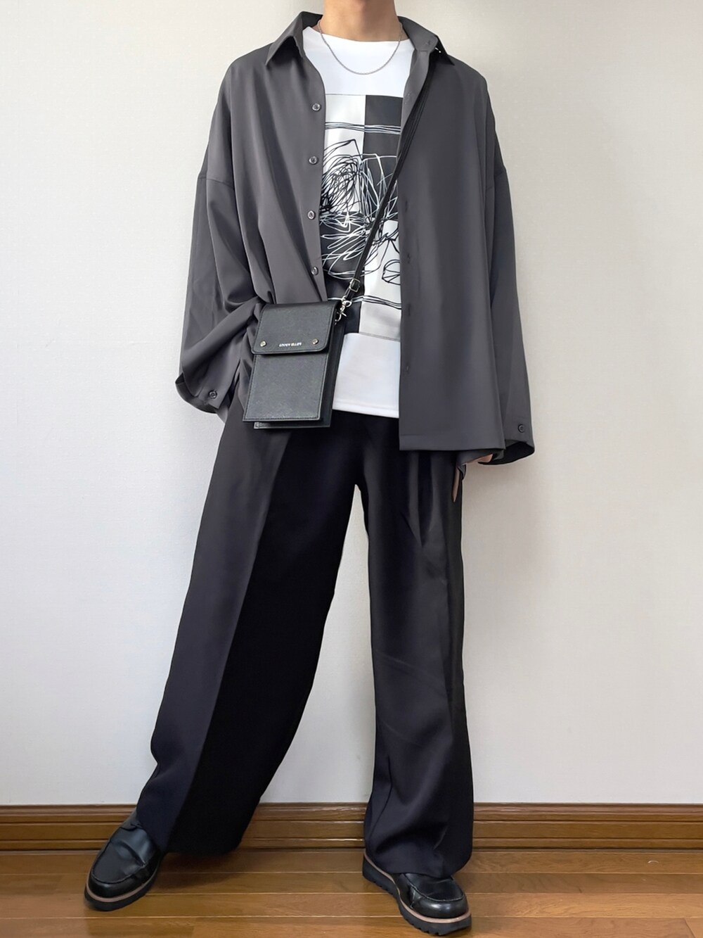 ブラック系のショルダーバッグ、グレー系のシャツ/ブラウス、ホワイト系のTシャツ/カットソーを着用したメンズの春コーディネートの2枚目の写真