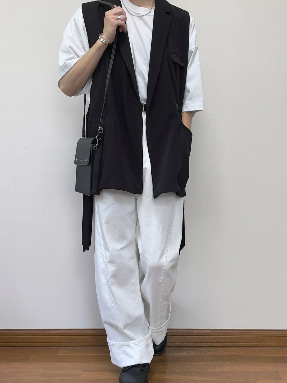 ホワイト系のデニムパンツ、ブラック系のドレスシューズ、ブラック系のベストを着用したメンズの夏コーディネートの3枚目の写真