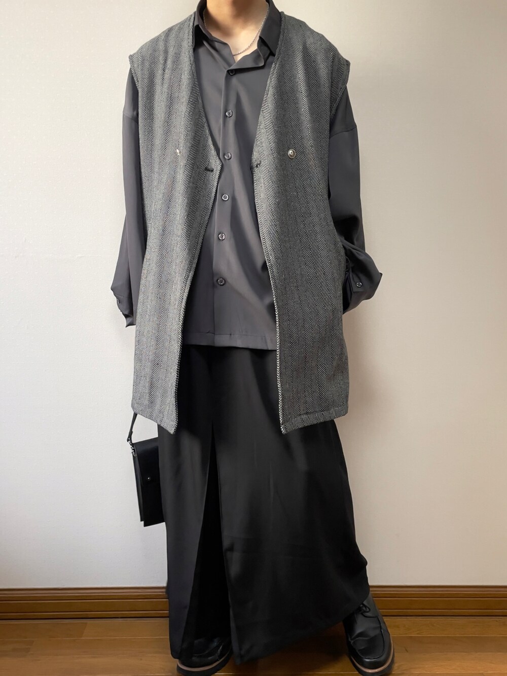 グレー系のシャツ/ブラウス、グレー系のベスト、ブラック系のショルダーバッグを着用したメンズの春コーディネートの3枚目の写真