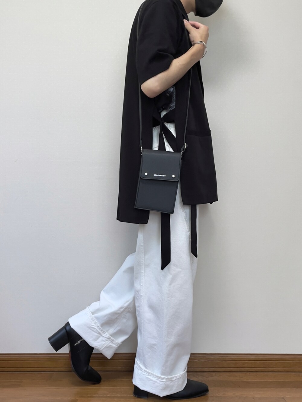 ホワイト系のデニムパンツ、ブラック系のブーツ、ブラック系のベストを着用したメンズの夏コーディネートの2枚目の写真