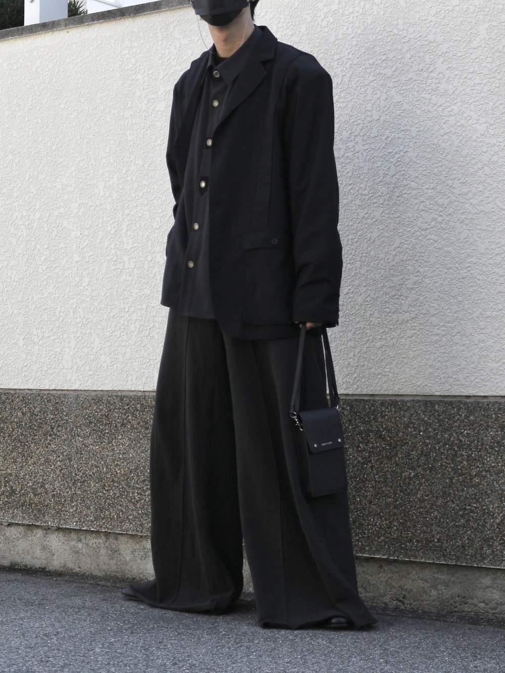 ブラック系のショルダーバッグ、ブラック系のスウェットパンツ、ブラック系のブーツを着用したメンズの秋コーディネートの2枚目の写真