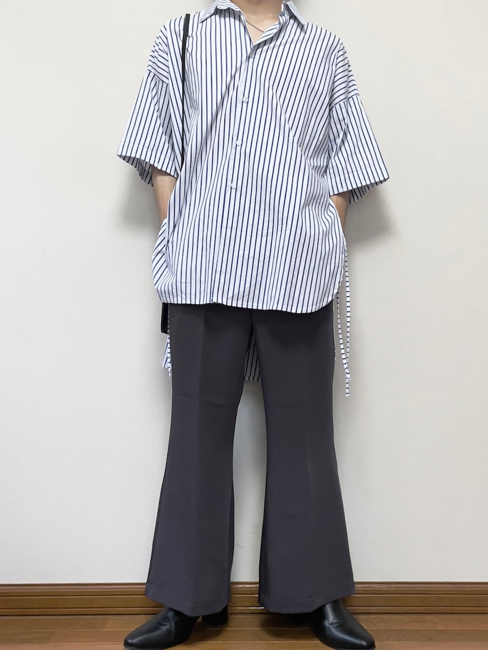 グレー系のスラックス、ホワイト系のシャツ/ブラウス、ブラック系のショルダーバッグを着用したメンズの夏コーディネートの3枚目の写真