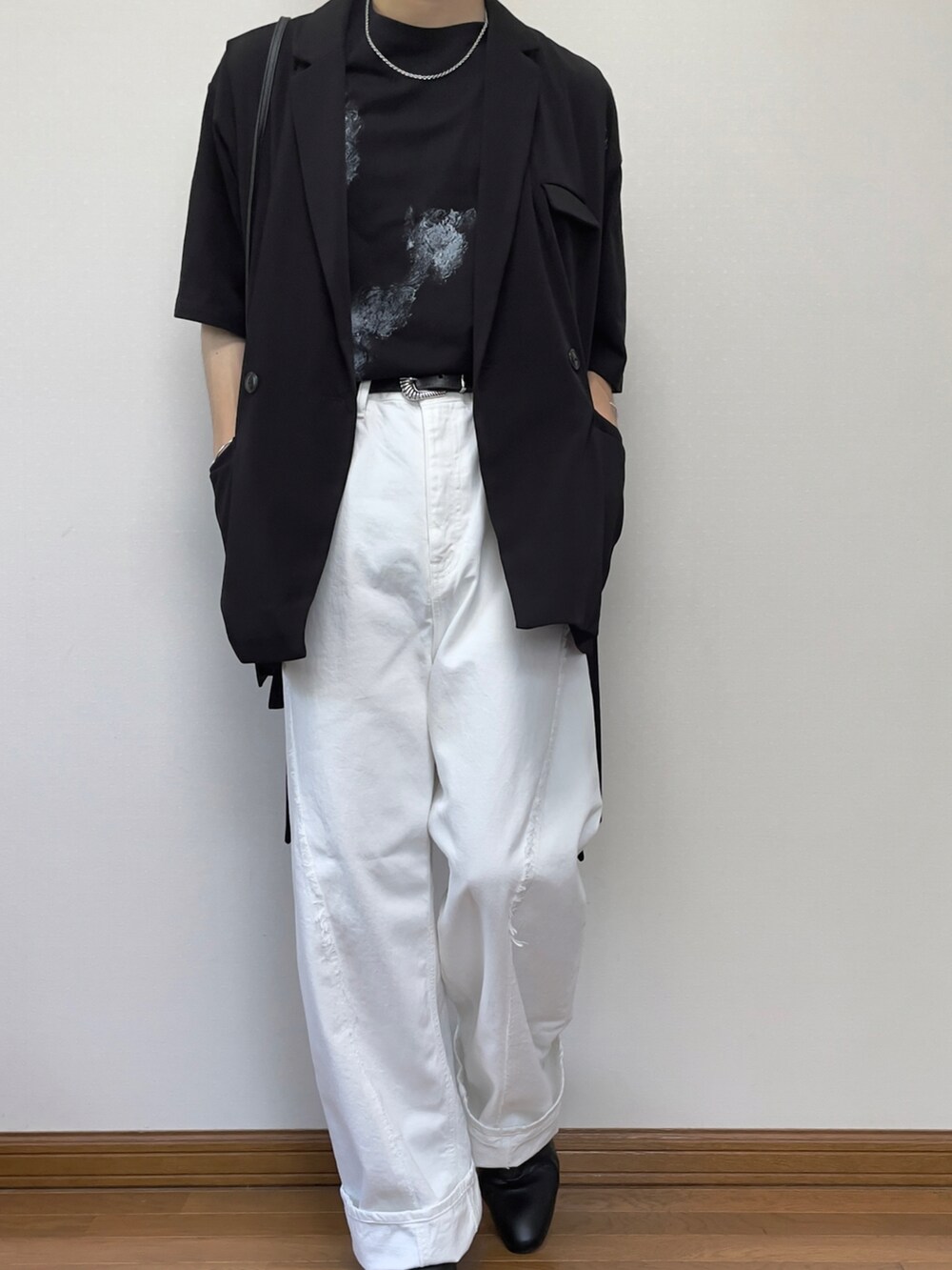 ホワイト系のデニムパンツ、ブラック系のブーツ、ブラック系のベストを着用したメンズの夏コーディネートの3枚目の写真