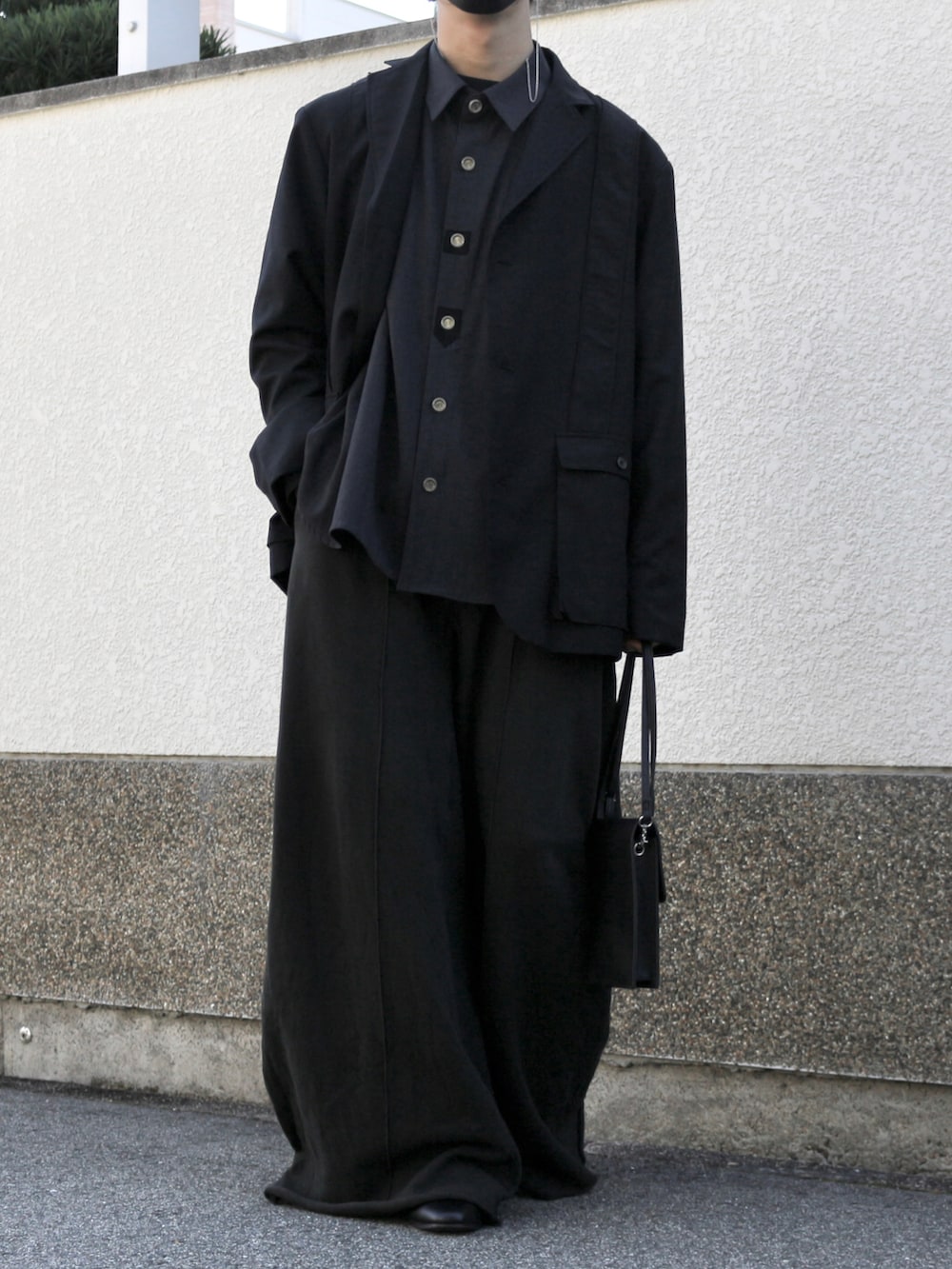 ブラック系のショルダーバッグ、ブラック系のスウェットパンツ、ブラック系のブーツを着用したメンズの秋コーディネートの3枚目の写真