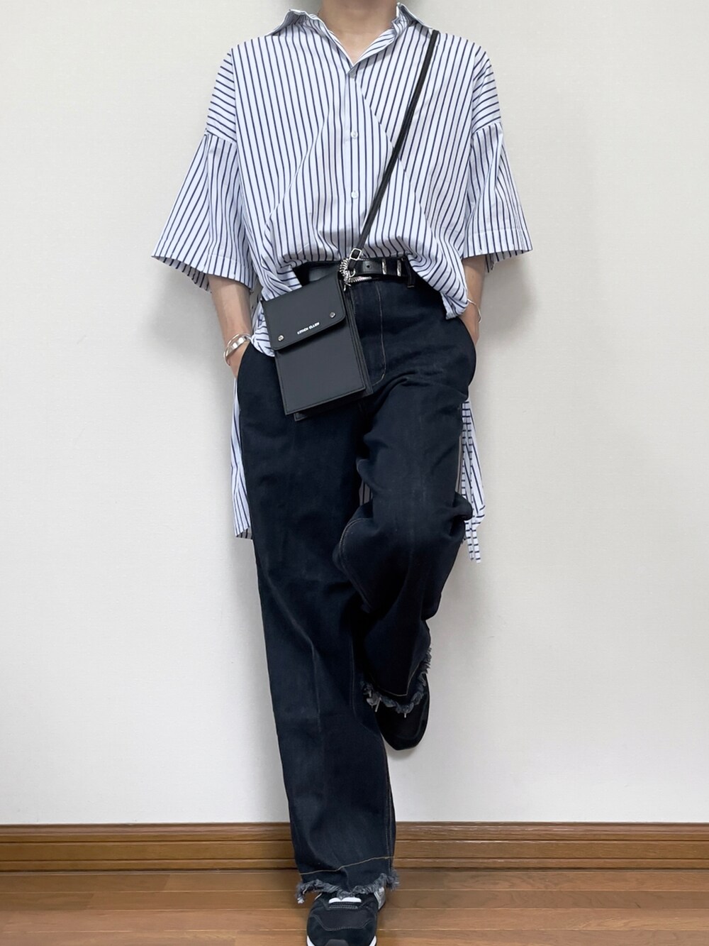 ブルー系のデニムパンツ、ブラック系のショルダーバッグ、ホワイト系のシャツ/ブラウスを着用したメンズの夏コーディネートの2枚目の写真