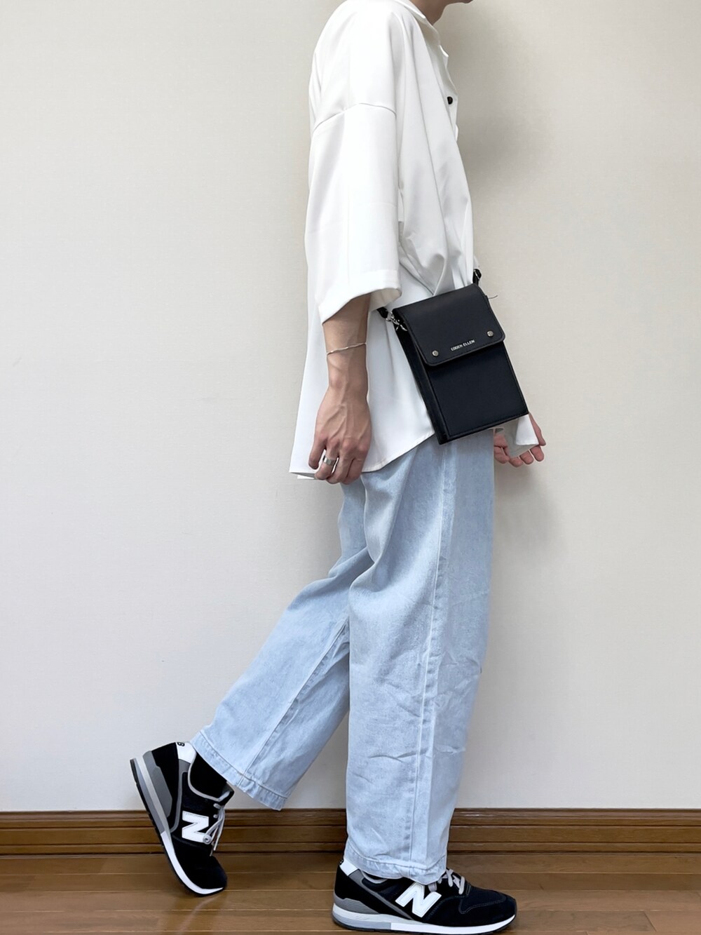 ブラック系のスニーカー、ブルー系のデニムパンツ、ホワイト系のシャツ/ブラウスを着用したメンズの夏コーディネートの3枚目の写真