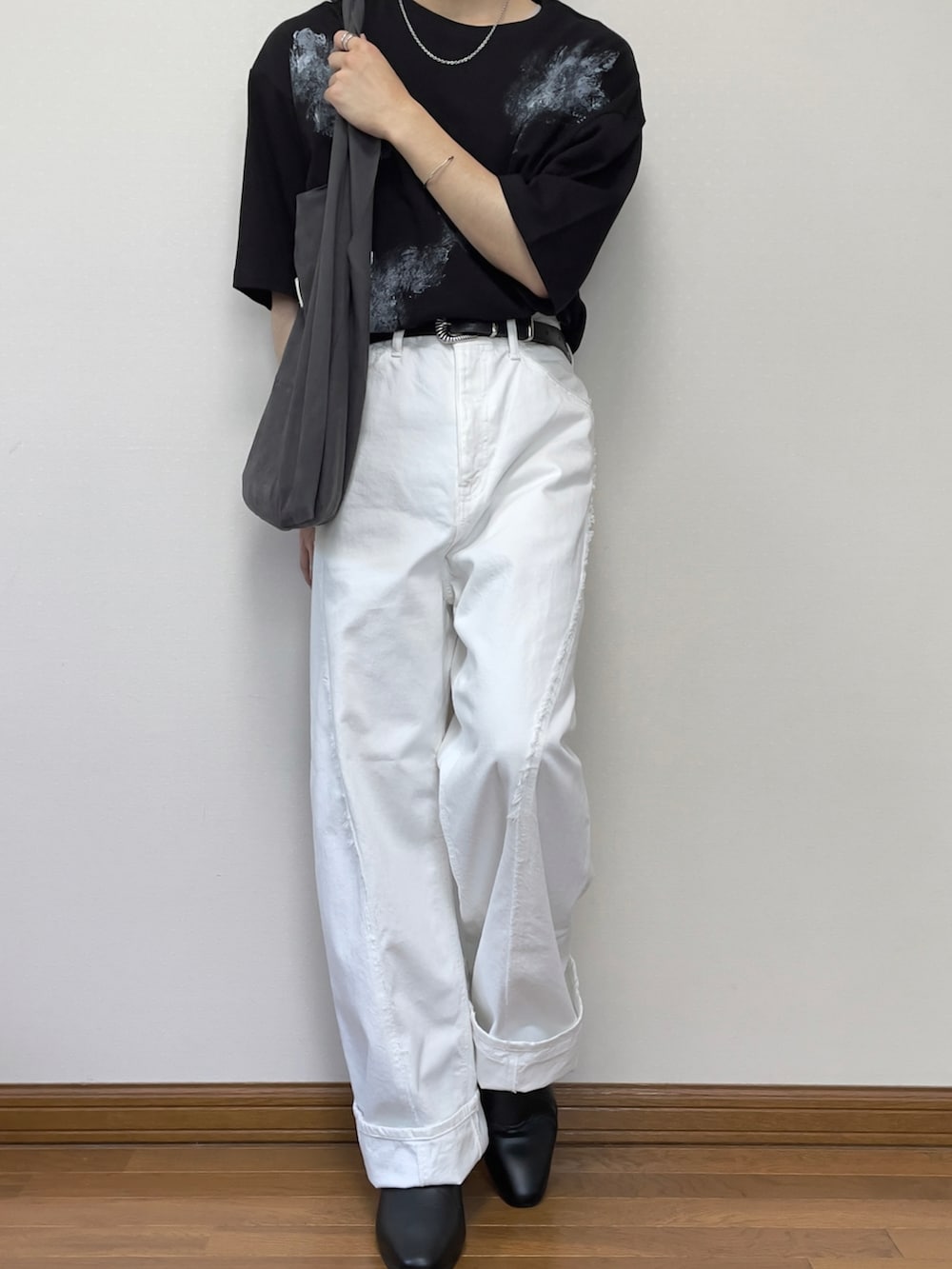 ホワイト系のデニムパンツ、ブラック系のブーツ、ブラック系のTシャツ/カットソーを着用したメンズの夏コーディネートの3枚目の写真