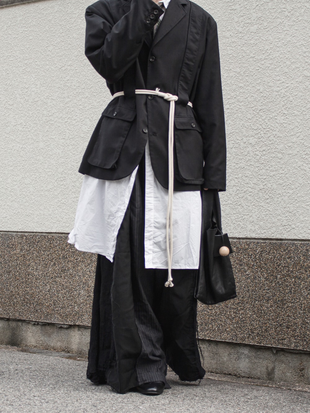 ブラック系のテーラードジャケット、ブラック系のスラックス、ホワイト系のシャツ/ブラウスを着用したメンズの秋コーディネートの3枚目の写真