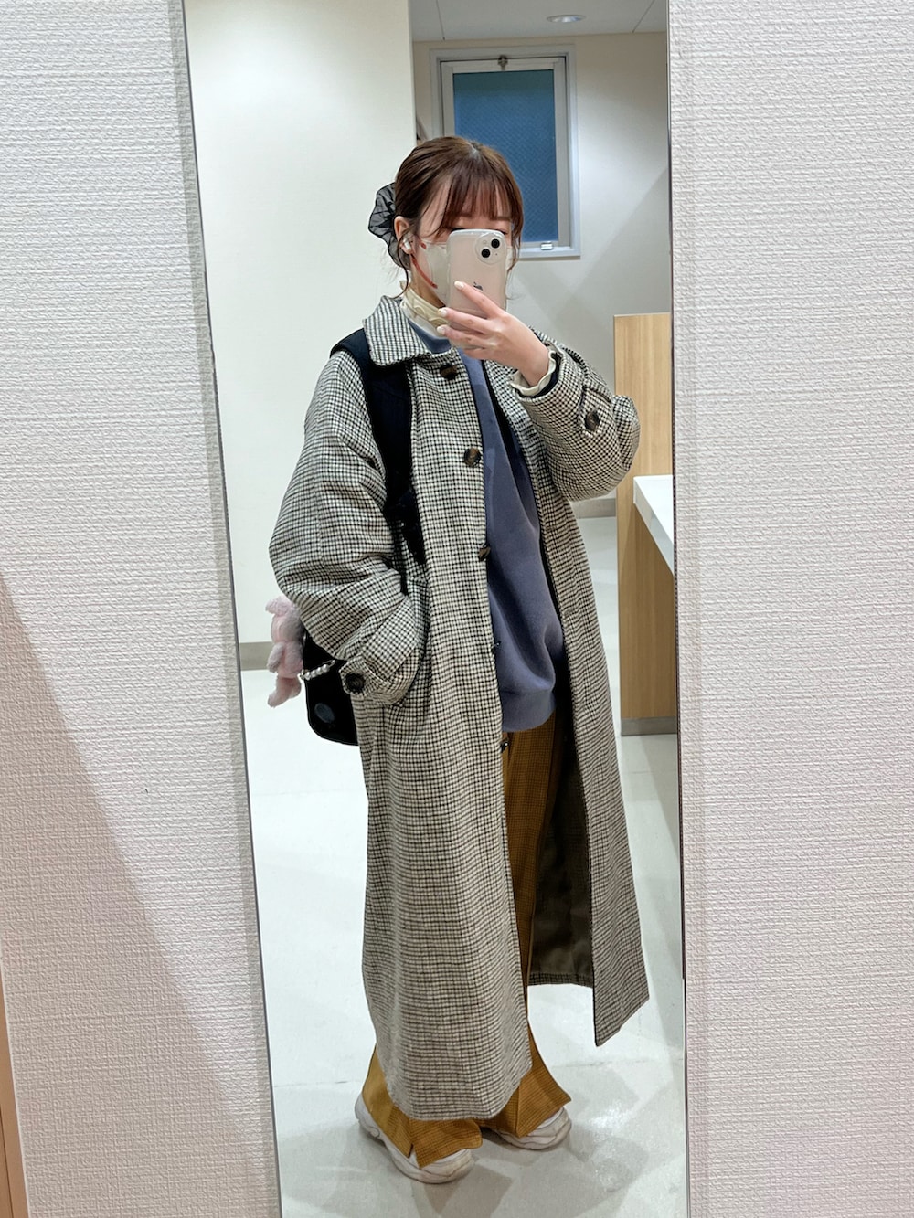 ブルー系のスウェット、イエロー系のパンツ、ベージュ系のその他トップスを着用したレディースの冬コーディネートの2枚目の写真