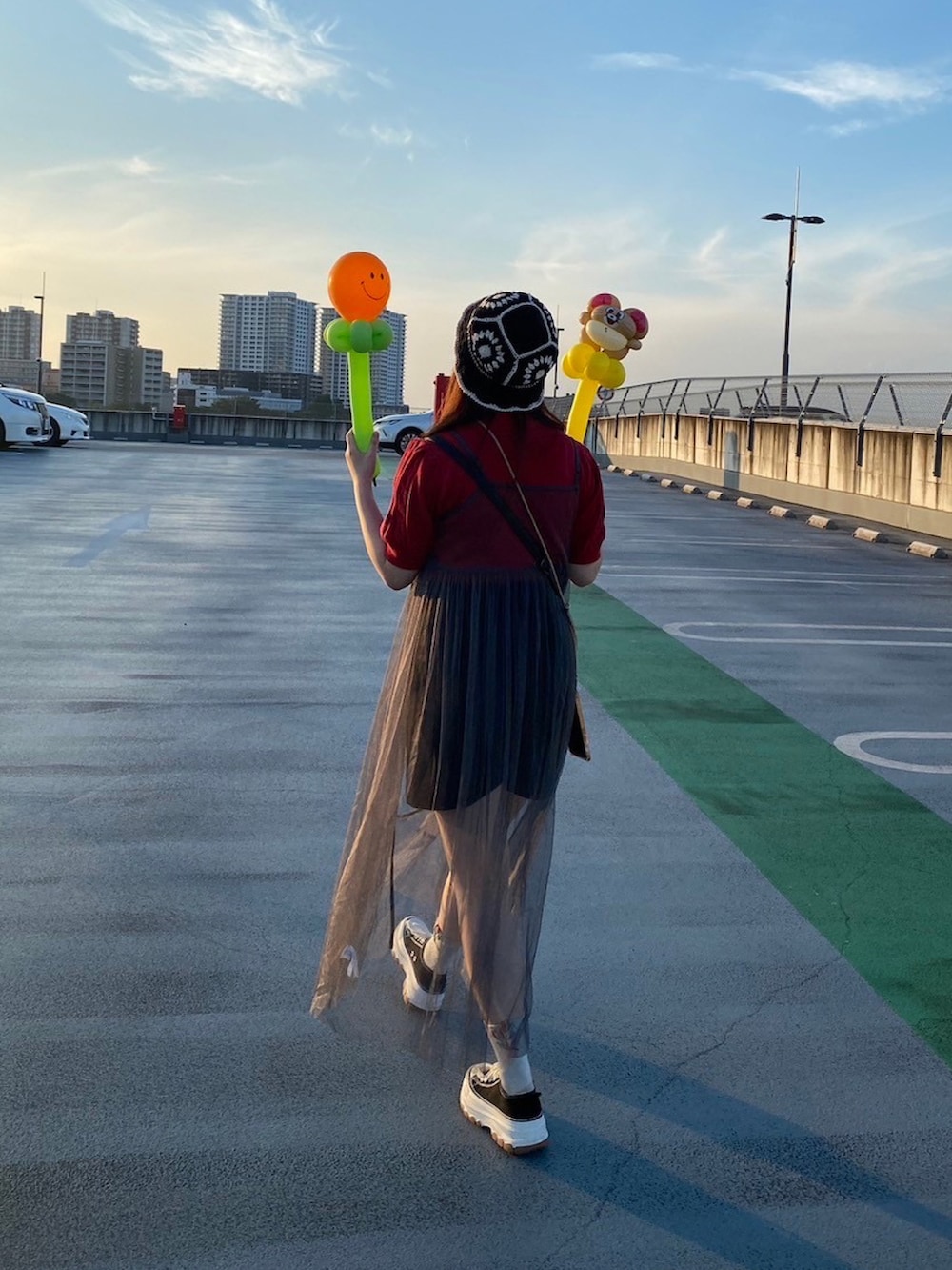 ブラック系のスニーカー、レッド系のニット/セーター、グレー系のトップスを着用したレディースの夏コーディネートの2枚目の写真